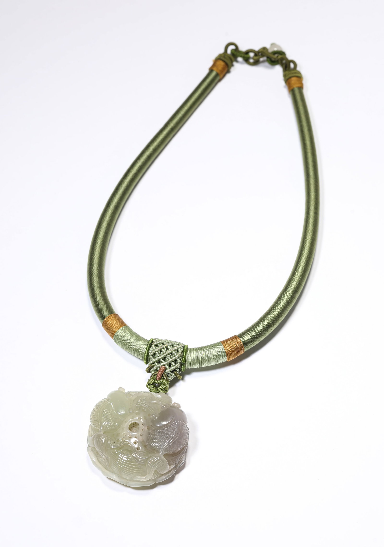 A Jade 'Floral Abundance' Pendant: A Jade 'Floral Abundance' Pendant Dimensions: Width: 4.8 cm (1.89 in) x Height: 2.0 cm (0.79 in). All measurements are approximate.
