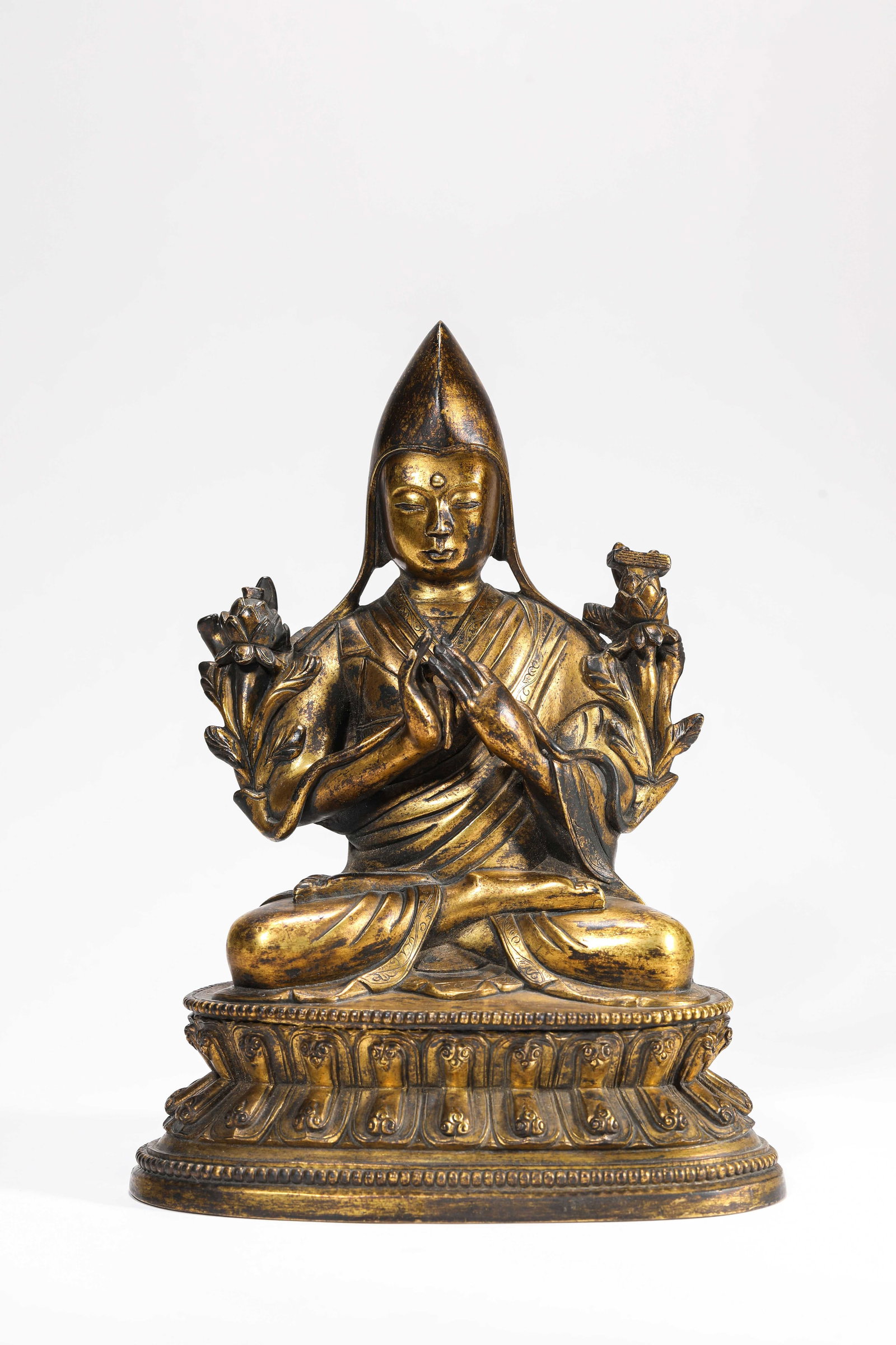 A Gilt-Bronze Figure of Tsongkhapa: A Gilt-Bronze Figure of Tsongkhapa Dimensions: Weight: 2252g. Length: 16.7 cm (6.57 in) x Width: 12.1 cm (4.76 in) x Height: 22.3 cm (8.78 in). All measurements are approximate.
