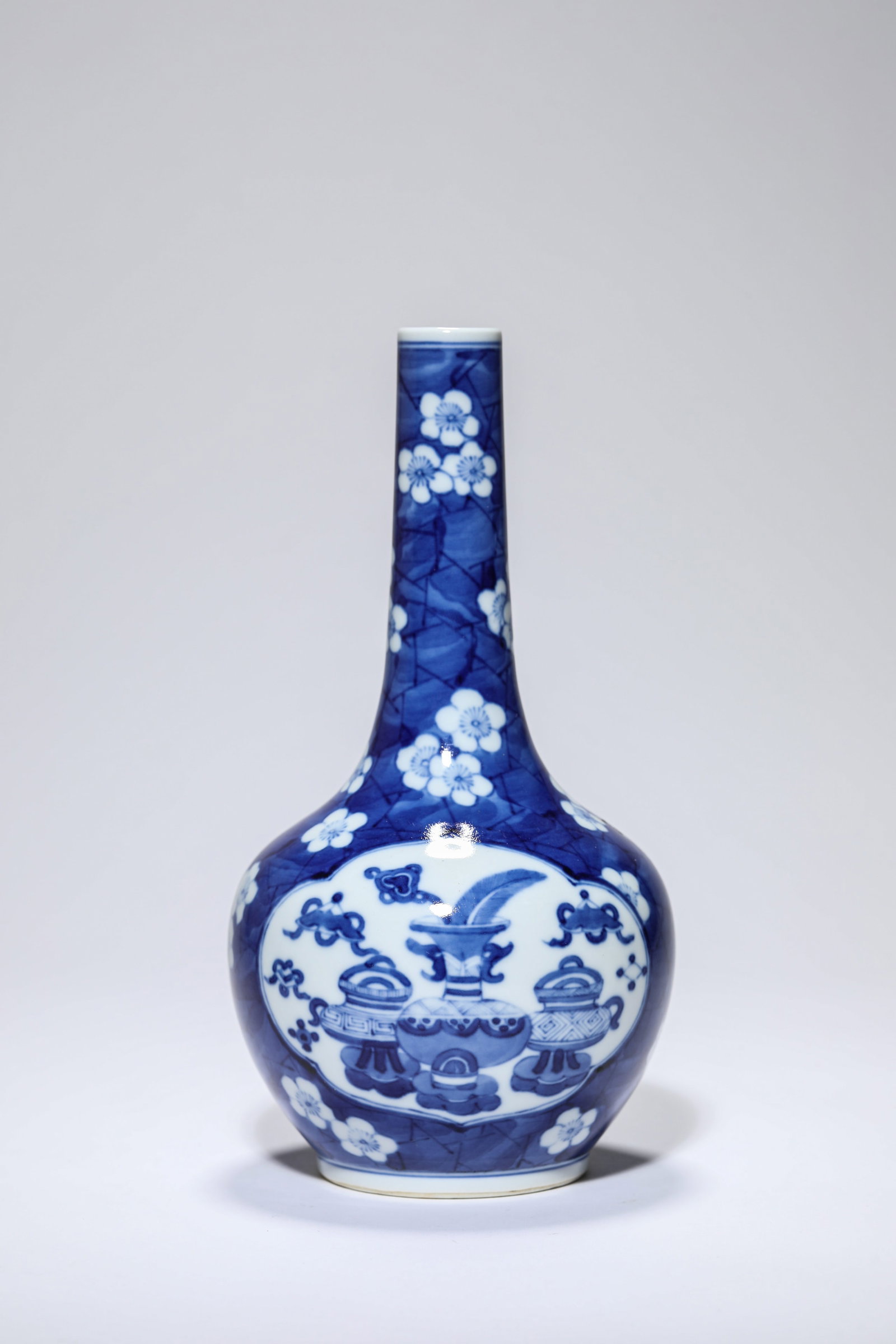 A Blue and White 'Ice-Form Plum and Antiquities' 'Long-Neck' Vase: A Blue and White 'Ice-Form Plum and Antiquities' 'Long-Neck' Vase Dimensions: Height: 21.5 cm (8.46 in). All measurements are approximate.