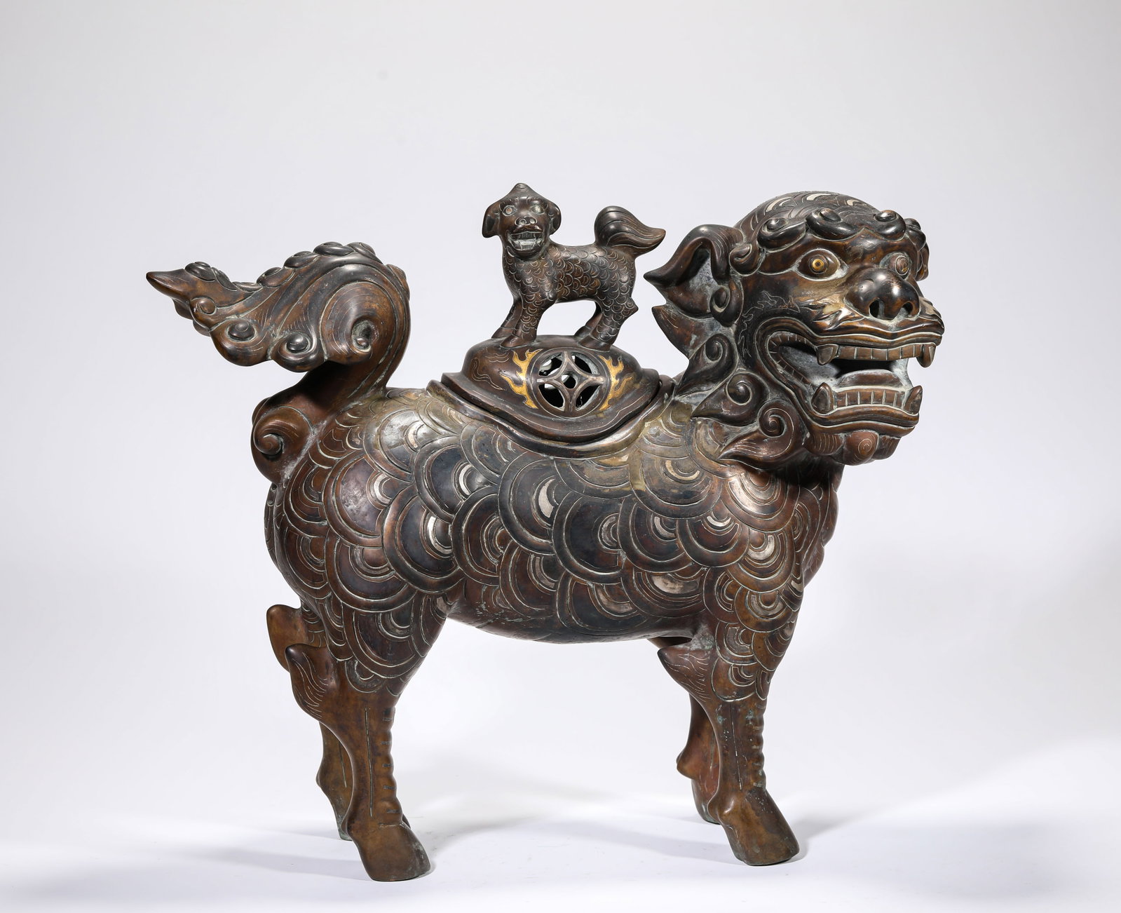 A Gold and Silver-Inlaid Bronze 'Lion' Censer: A Gold and Silver-Inlaid Bronze 'Lion' Censer Dimensions: Weight: 16kg. Length: 44.0 cm (17.32 in) x Width: 16.5 cm (6.50 in) x Height: 36.0 cm (14.17 in). All measurements are approximate.
