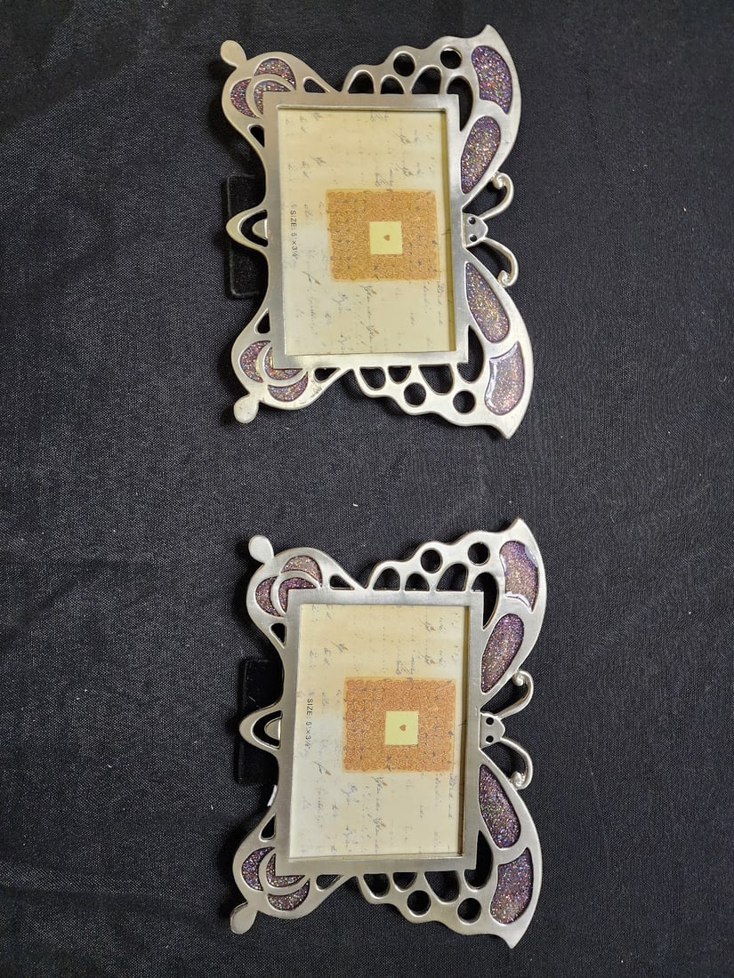 Pair of Butterfly Metal Picture Frames: Elegant set of two butterfly-shaped metal picture frames with purple glitter accents and a silver-tone finish. Each frame holds a 5” x 3½” photo and features a whimsical, decorative