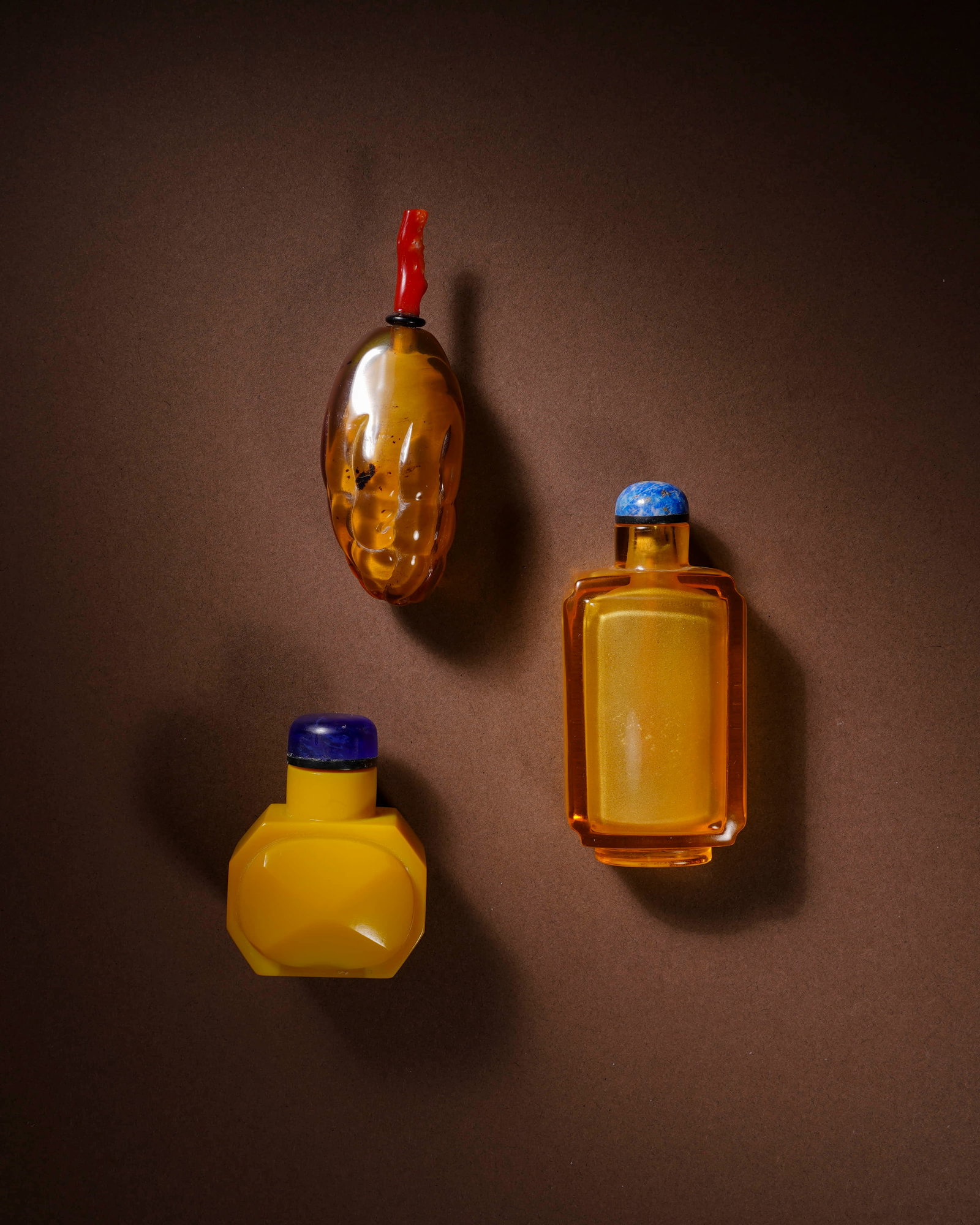 Clear amber snuff bottles a group of three.: L:3.5cm H:7.8cm /L:2.8cm H:7.8cm /L:3.8cm H:5.2cm