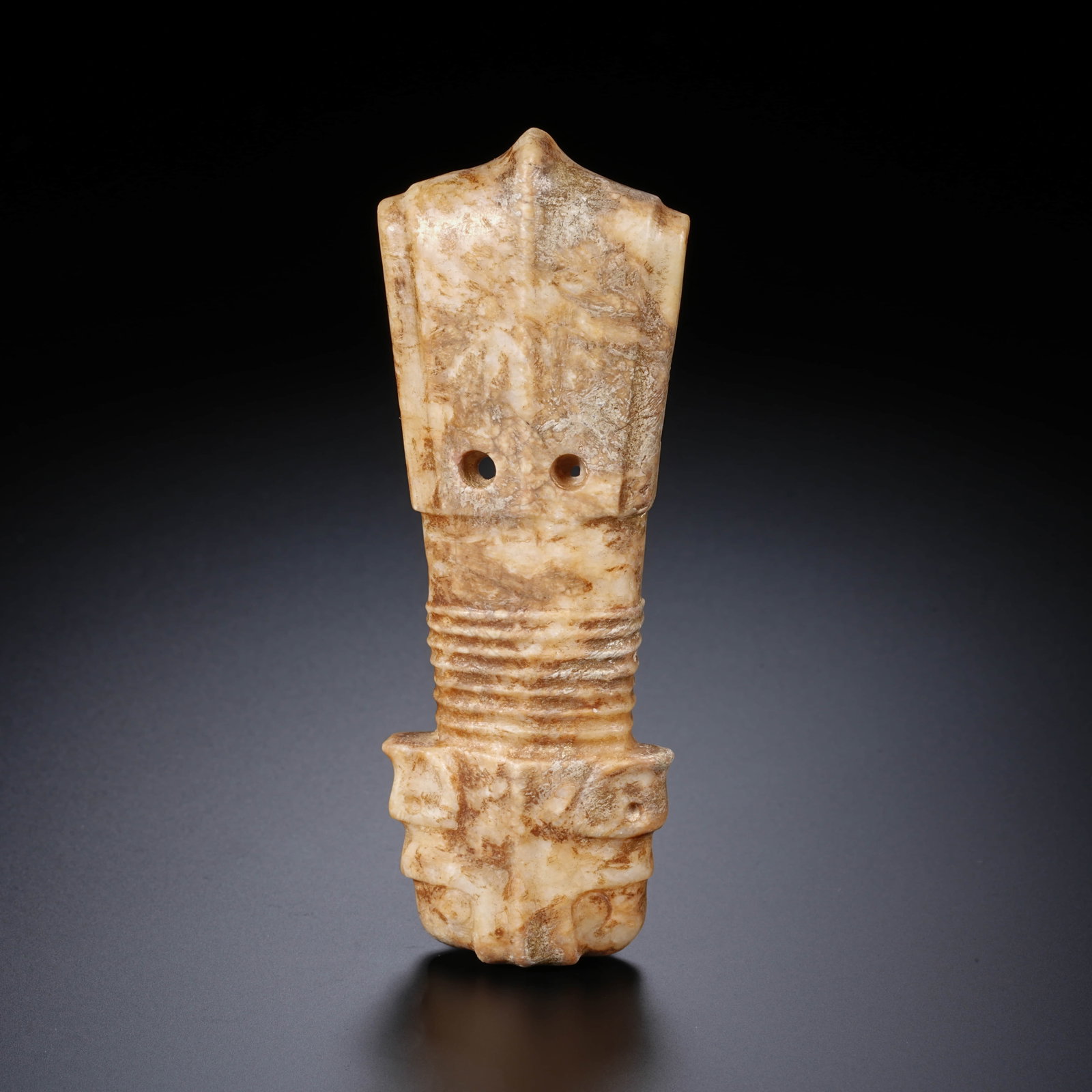 A CHINESE ARCHAIC JADE ORNAMENT: This jade object features an elongated, flattened form, resembling a stylized cicada or animal mask pendant. The piece is structured into three distinct sections: the upper portion is broader and