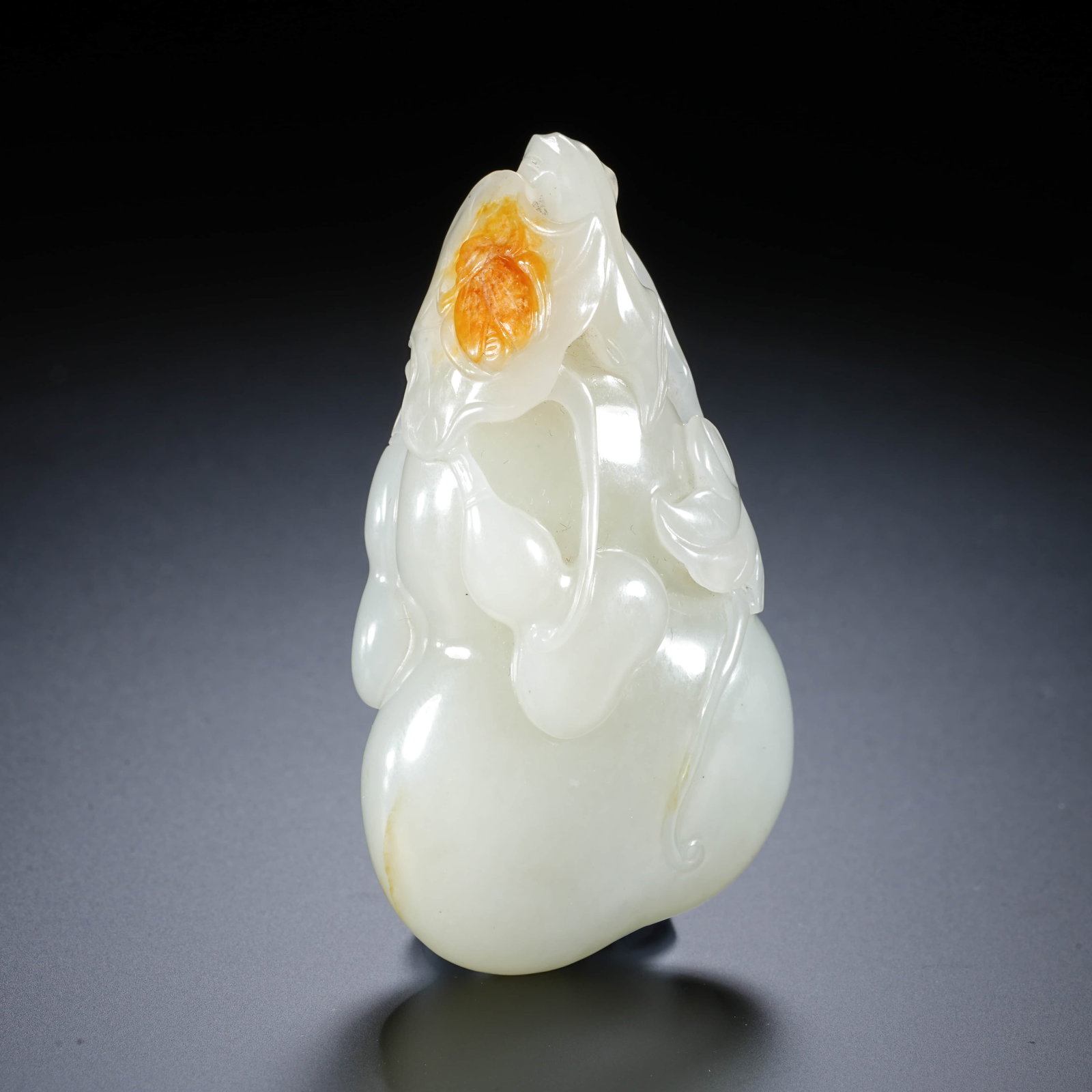 A CHINESE WHITE JADE GOURD PENDANT WITH SKIN INCLUSIONS: his jade object is carved from a single stone in high relief and in the round, depicting interlocking large and small gourds. The piece has a well-rounded and plump form, with a large gourd forming