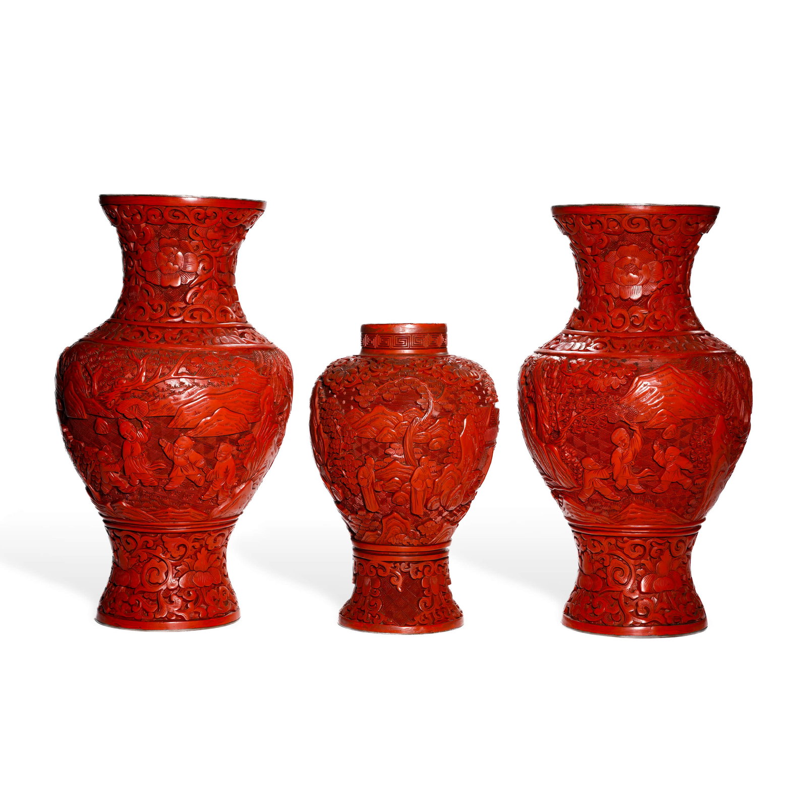 A SET OF CHINESE CARVED CINNABAR LACQUER 'INFANTS PLAYING' VASES: This group consists of three cinnabar lacquer vases. The outer pair comprises two identical vessels featuring flared mouths, constricted necks, generous shoulders, and ovoid bodies tapering down to sp