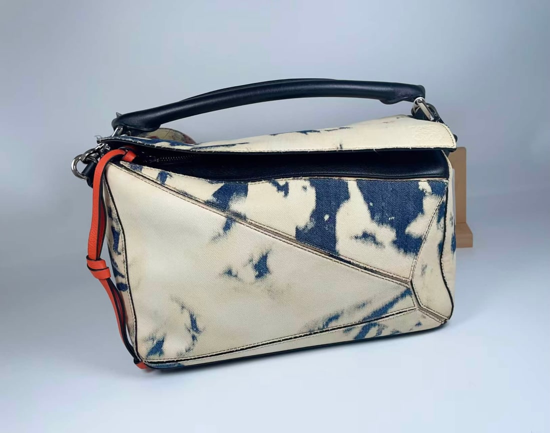 Luo Yiwei -Puzzle series tie-dyed denim handbags: Luo Yiwei -Puzzle series tie-dyed denim handbags adopt the brand's iconic geometric stitching structure. Tie-dyed denim materials collide with black and orange contrast details. The handle and shoulde