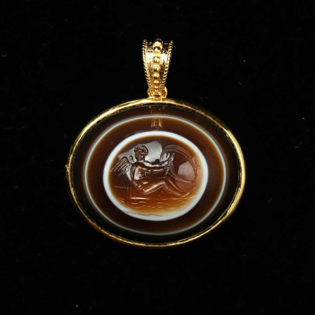 Gold Pendant with Silk-wrapped Agate Angel Print in Ancient Rome: Ancient Roman gold pendant with silk-wrapped agate angel print.Carving the scene of Cupid drifting in love with an arrow propped up by a silk-wrapped agate is exquisite in carving and full of artistic
