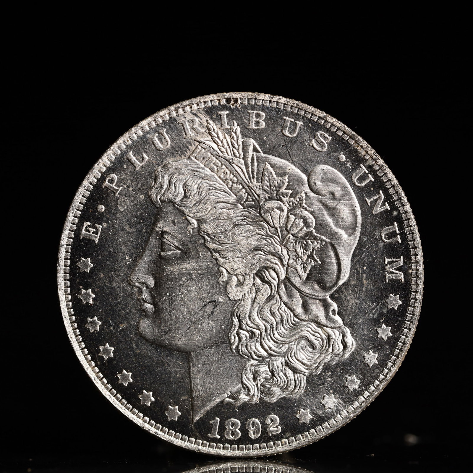 USA Morgan Dollar 1892 Coin: Obv: profile bust with date below and E PLURIBUS UNUM legend and stars around. Rev: eagle with In God we trust above within wreath with UNITED STATES OF AMERICA ONE DOLLAR legend. IN GOD WE TRUST / LI