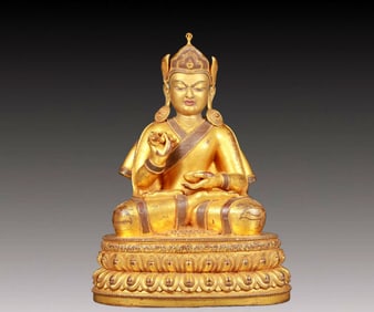 A solemn gilt bronze statue of the master