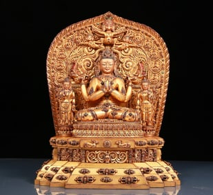 A solemn gilt bronze statue of Guanyin with four arms inlaid with precious stones