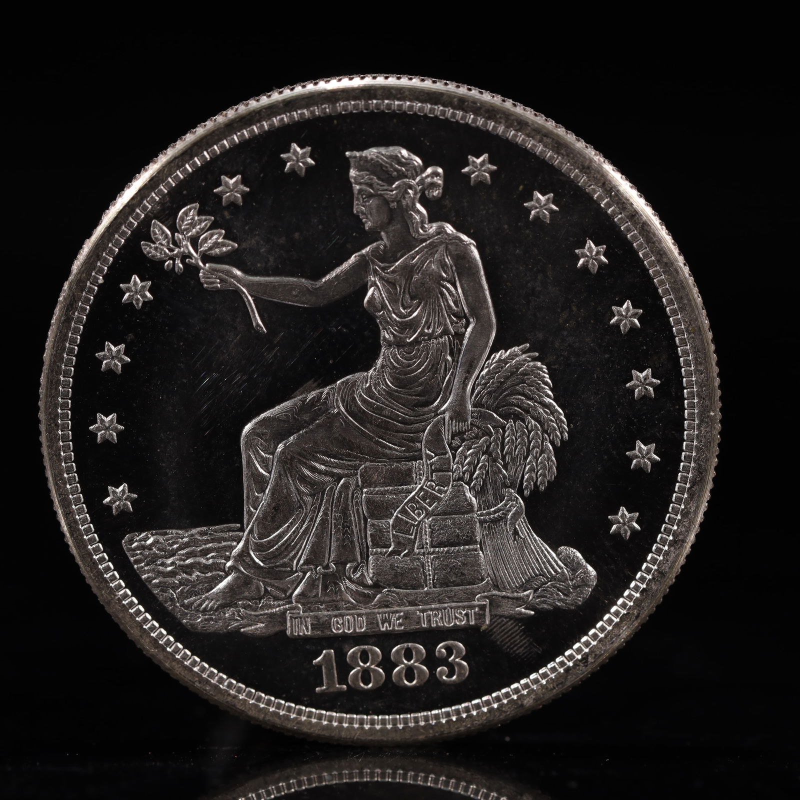 USA Trade Dollar 1883 Coin: American coin. Obverse: Liberty seated on a pedestal facing the sea to the left holding olive branches surrounded by 13 stars. IN GOD WE TRUST / LIBERTY / 1883. Reverse: An eagle holding branches
