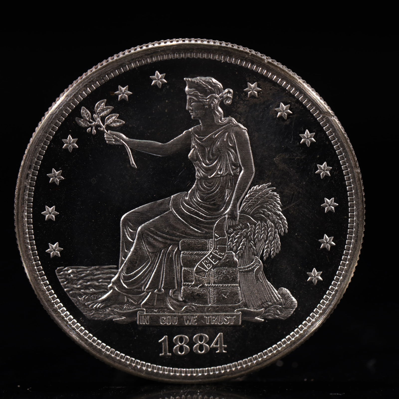 USA Trade Dollar 1884 Coin: American coin. Obverse: Liberty seated on a pedestal facing the sea to the left holding olive branches surrounded by 13 stars. IN GOD WE TRUST / LIBERTY / 1884. Reverse: An eagle holding branches