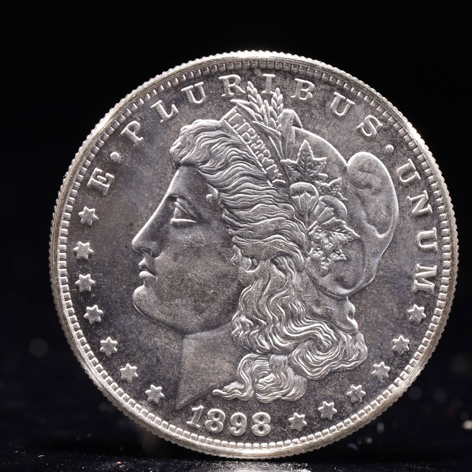 USA Morgan Dollar 1898 Coin: Obv: profile bust with date below and E PLURIBUS UNUM legend and stars around. Rev: eagle with In God we trust above within wreath with UNITED STATES OF AMERICA ONE DOLLAR legend. IN GOD WE TRUST /
