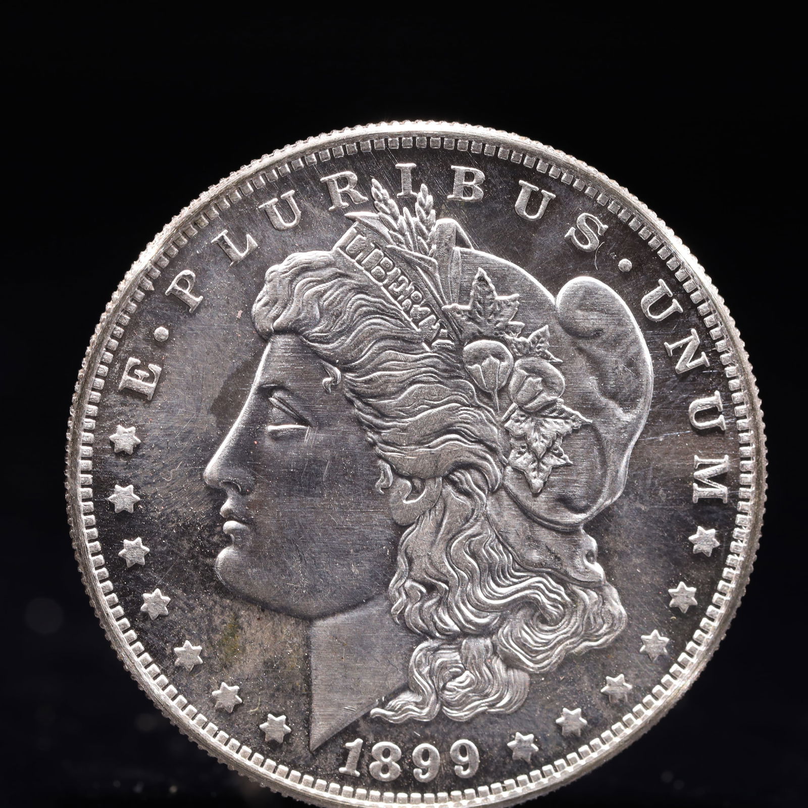 USA Morgan Dollar 1899 Coin: Obv: profile bust with date below and E PLURIBUS UNUM legend and stars around. Rev: eagle with In God we trust above within wreath with UNITED STATES OF AMERICA ONE DOLLAR legend. IN GOD WE TRUST /