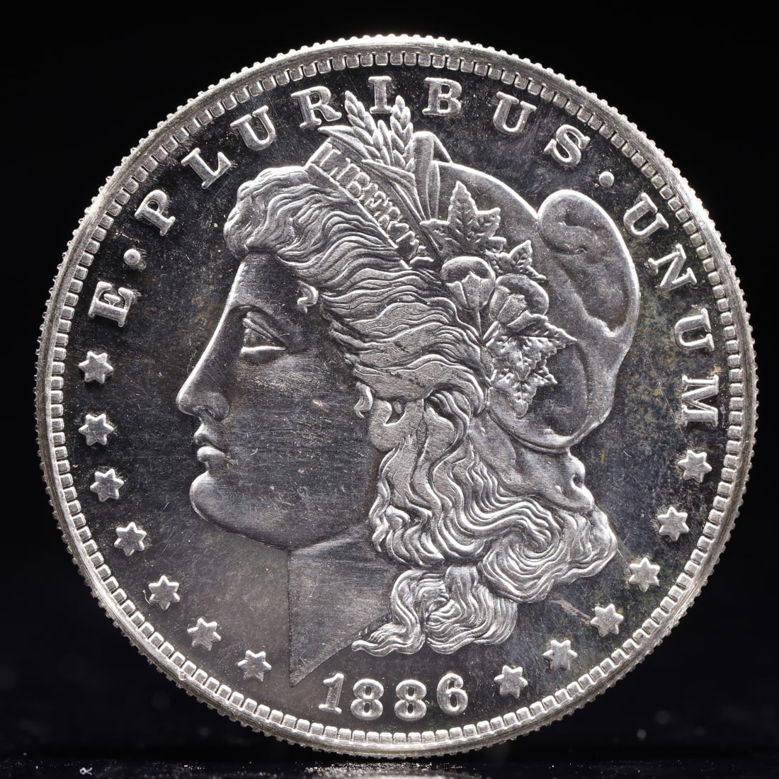 USA Morgan Dollar 1886 Coin: Obv: profile bust with date below and E PLURIBUS UNUM legend and stars around. Rev: eagle with In God we trust above within wreath with UNITED STATES OF AMERICA ONE DOLLAR legend. IN GOD WE TRUST /