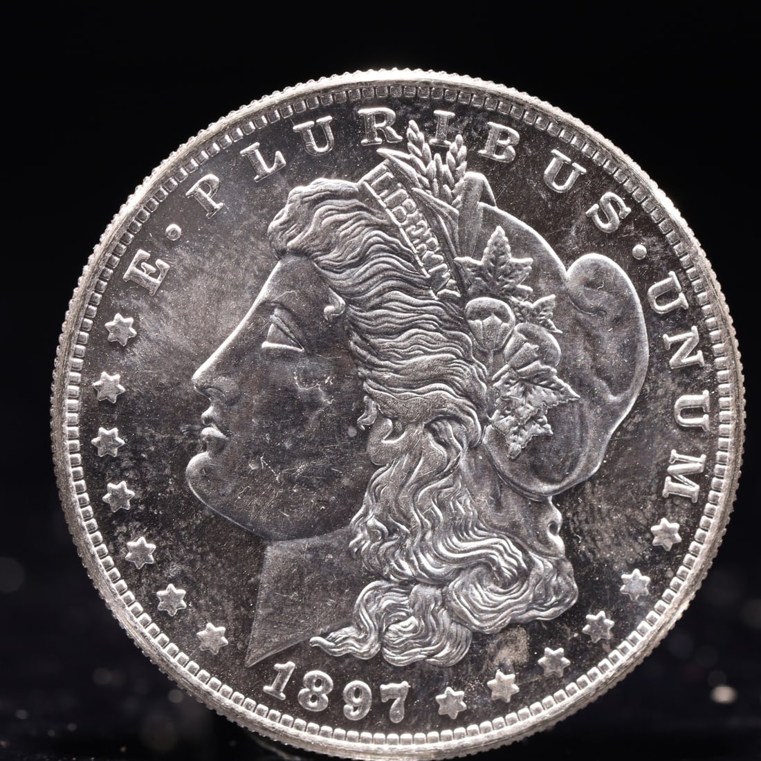 USA Morgan Dollar 1897 Coin: Obv: profile bust with date below and E PLURIBUS UNUM legend and stars around. Rev: eagle with In God we trust above within wreath with UNITED STATES OF AMERICA ONE DOLLAR legend. IN GOD WE TRUST /
