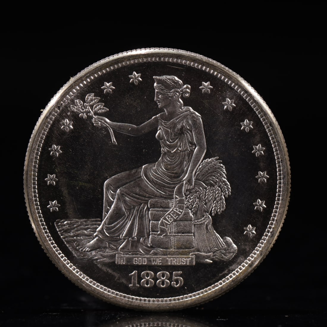 USA Trade Dollar 1885 Coin: American coin. Obverse: Liberty seated on a pedestal facing the sea to the left holding olive branches surrounded by 13 stars. IN GOD WE TRUST / LIBERTY / 1885. Reverse: An eagle holding branches