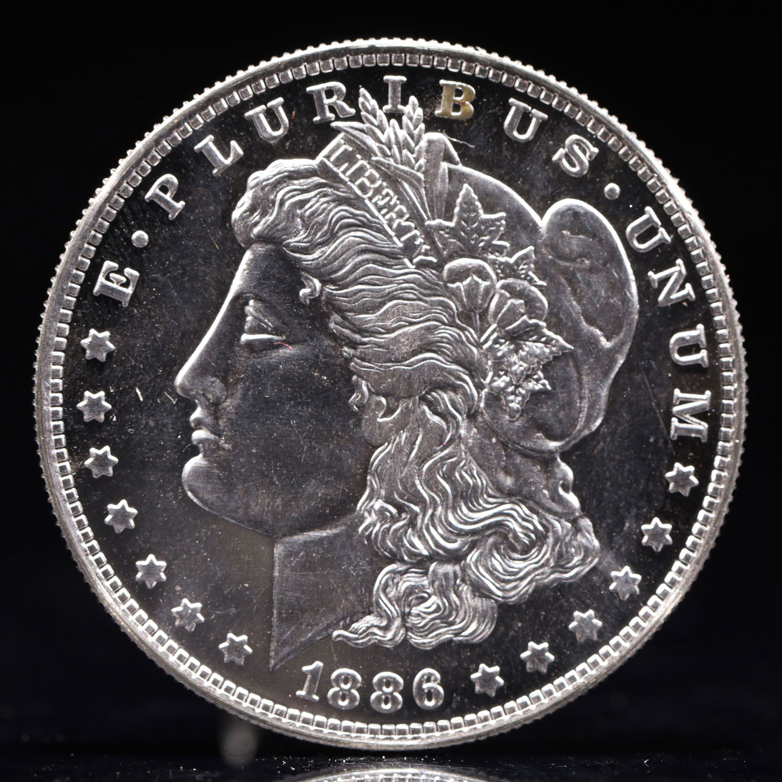 USA Morgan Dollar 1886 Coin: Obv: profile bust with date below and E PLURIBUS UNUM legend and stars around. Rev: eagle with In God we trust above within wreath with UNITED STATES OF AMERICA ONE DOLLAR legend. IN GOD WE TRUST / LI
