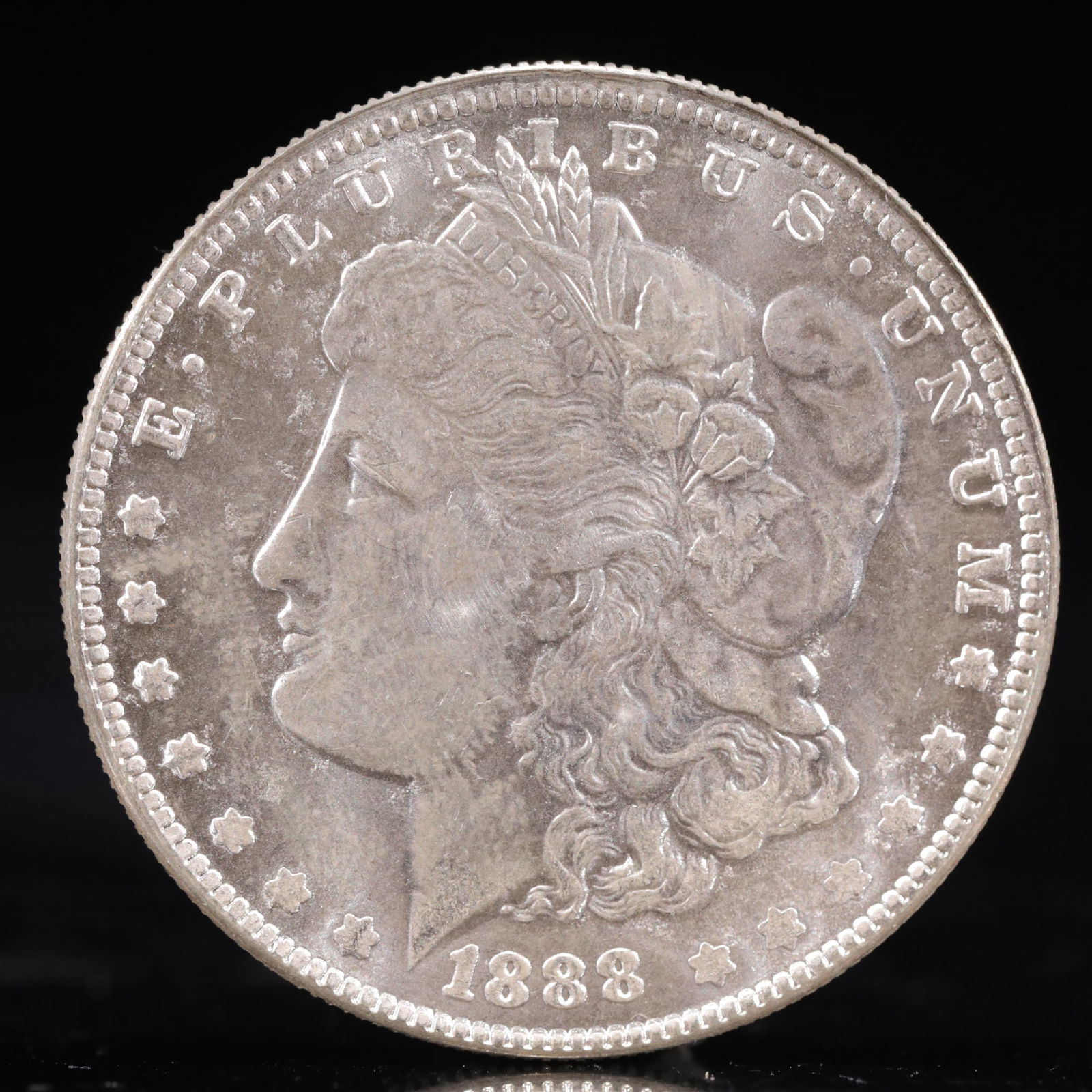USA Morgan Dollar 1888 Coin: Obv: profile bust with date below and E PLURIBUS UNUM legend and stars around. Rev: eagle with In God we trust above within wreath with UNITED STATES OF AMERICA ONE DOLLAR legend. IN GOD WE TRUST / LI