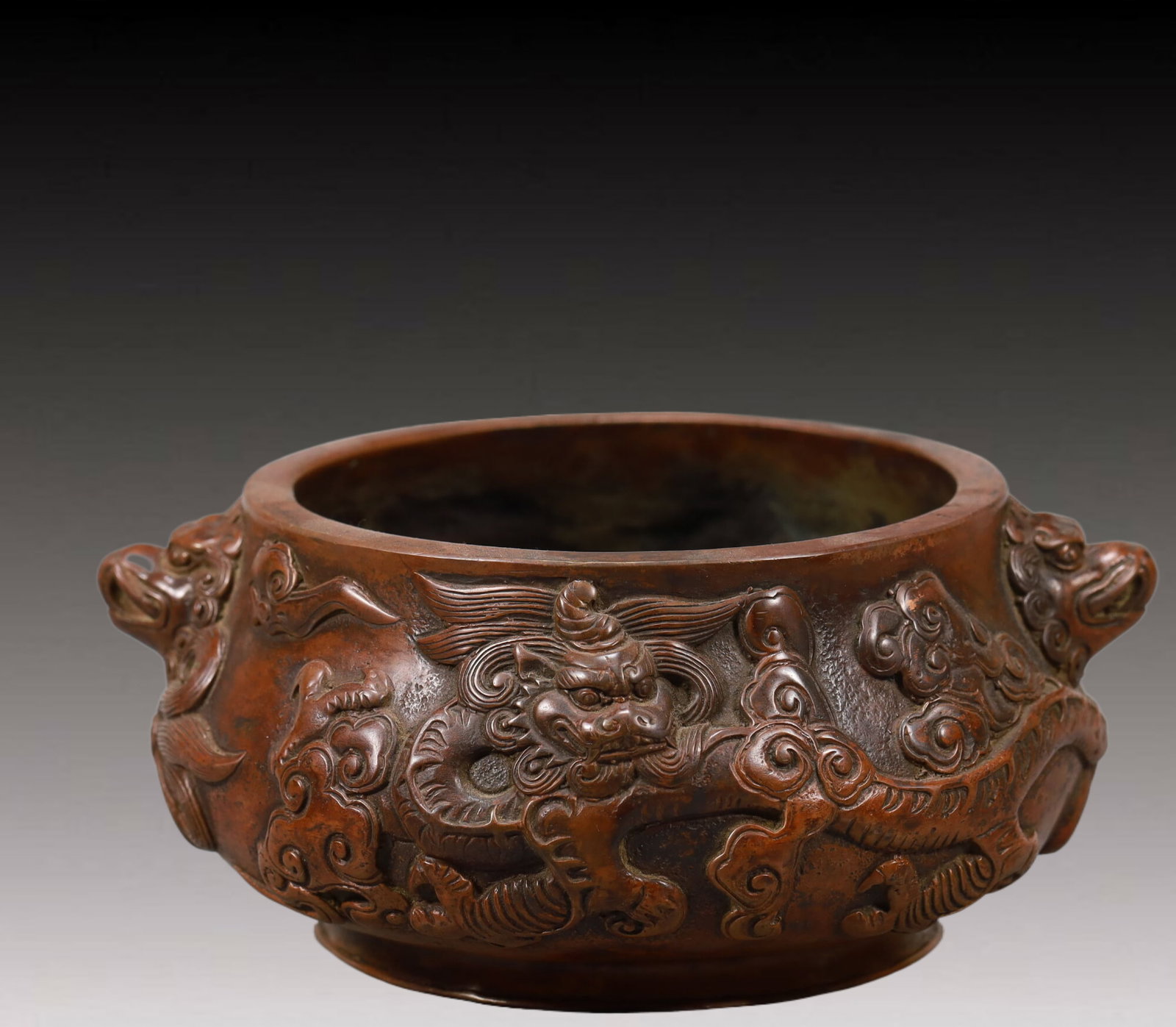 An Elaborate Bronze 'Dragon& Auspicious Cloud' Lion-Handled Censer: An Elaborate Bronze 'Dragon& Auspicious Cloud' Lion-Handled Censer. Of compressed form,body cast with scaly,sinuous dragons writhing amidst dense,scrolling clouds,all supported on a subtly splayed foo