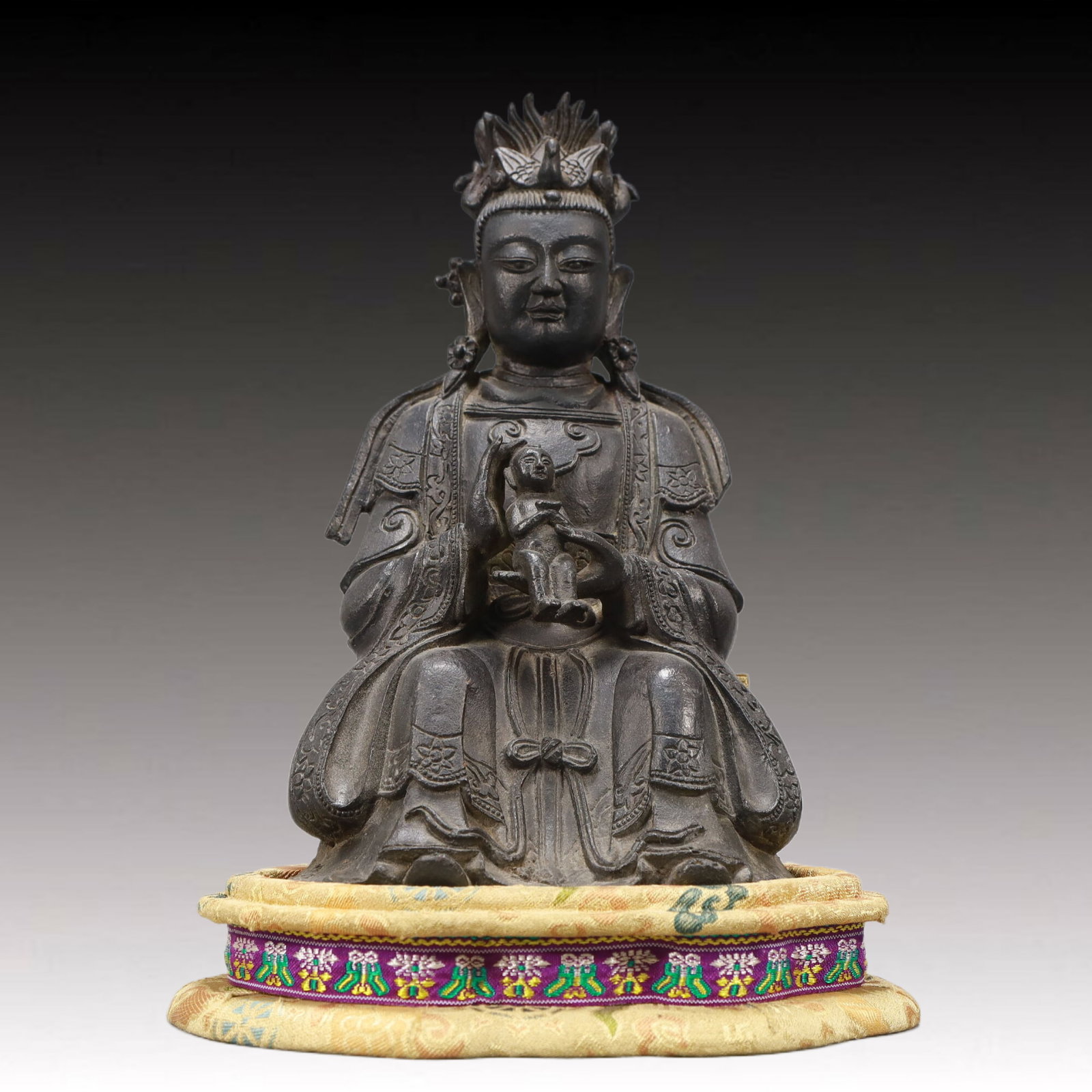 An Excellent Bronze Figure Of Guanyin And A Boy: An Excellent Bronze Figure Of Guanyin And A Boy. Seated with a benevolent expression,body rendered clad in long,flowing robes,the voluminous drapery elegantly cascading in folds. Chinese Ming
