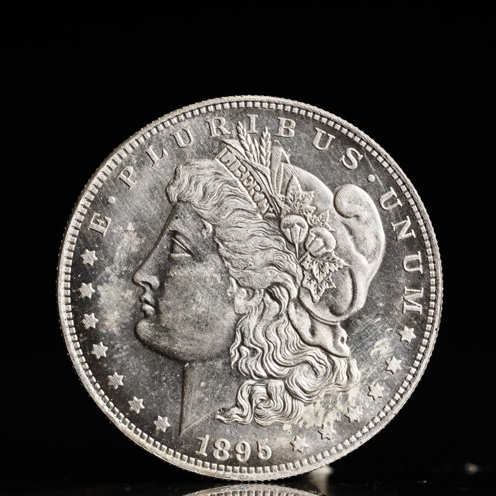 USA Morgan Dollar 1895 Coin: Obv: profile bust with date below and E PLURIBUS UNUM legend and stars around. Rev: eagle with In God we trust above within wreath with UNITED STATES OF AMERICA ONE DOLLAR legend. IN GOD WE TRUST /