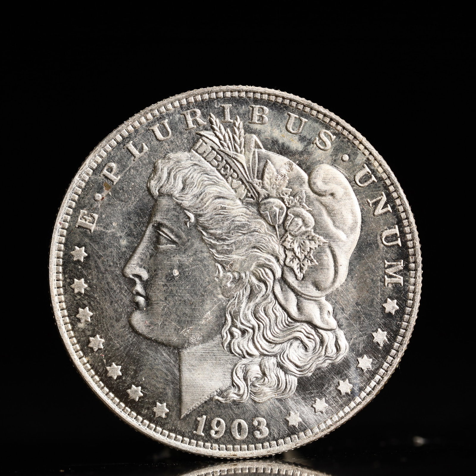 USA Morgan Dollar 1903 Coin: Obv: profile bust with date below and E PLURIBUS UNUM legend and stars around. Rev: eagle with In God we trust above within wreath with UNITED STATES OF AMERICA ONE DOLLAR legend. IN GOD WE TRUST / LI