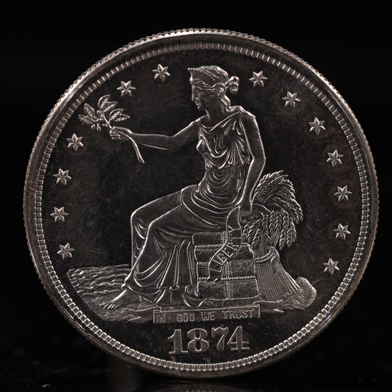 USA Trade Dollar 1874 Coin: American coin. Obverse: Liberty seated on a pedestal facing the sea to the left holding olive branches surrounded by 13 stars. IN GOD WE TRUST / LIBERTY / 1874. Reverse: An eagle holding branches with