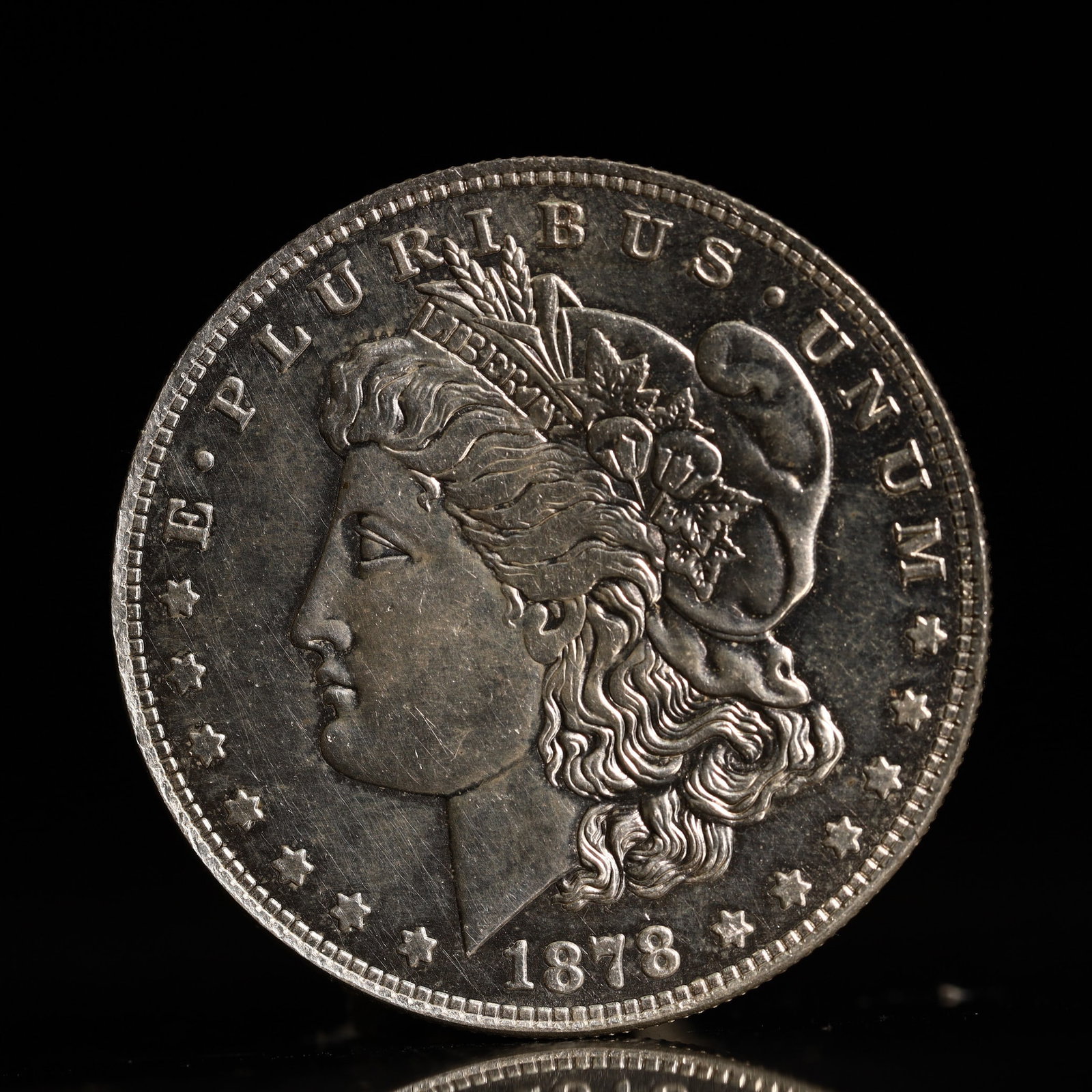 USA Morgan Dollar 1878 Coin: Obv: profile bust with date below and E PLURIBUS UNUM legend and stars around. Rev: eagle with In God we trust above within wreath with UNITED STATES OF AMERICA ONE DOLLAR legend. IN GOD WE TRUST / LI