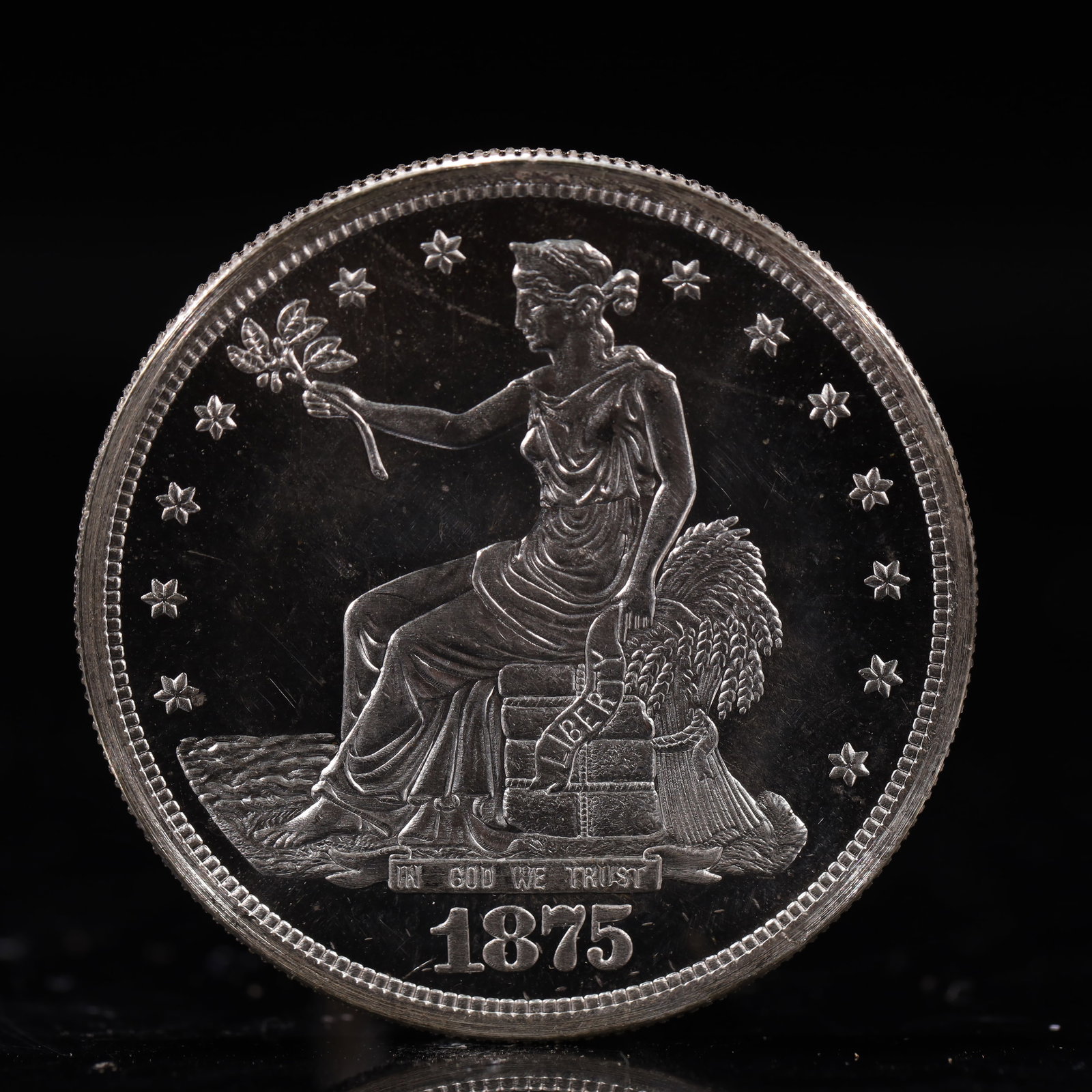 USA Trade Dollar 1875 Coin: American coin. Obverse: Liberty seated on a pedestal facing the sea to the left holding olive branches surrounded by 13 stars. IN GOD WE TRUST / LIBERTY / 1875. Reverse: An eagle holding branches with