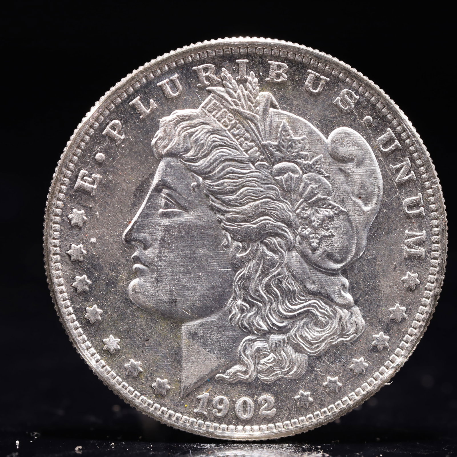 USA Morgan Dollar 1902 Coin: Obv: profile bust with date below and E PLURIBUS UNUM legend and stars around. Rev: eagle with In God we trust above within wreath with UNITED STATES OF AMERICA ONE DOLLAR legend. IN GOD WE TRUST / LI
