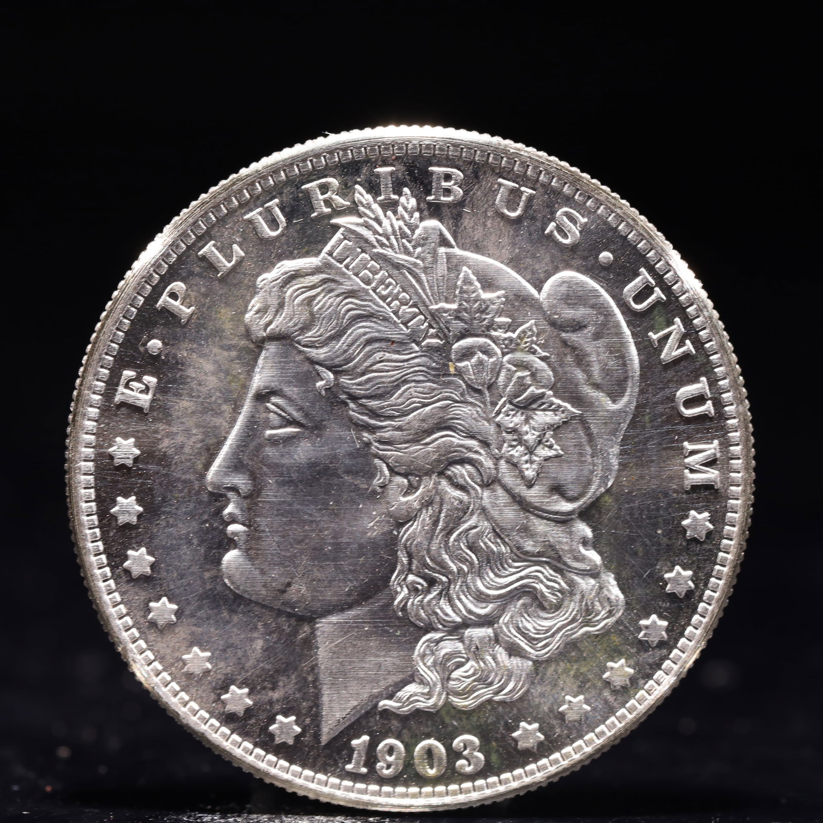 USA Morgan Dollar 1903 Coin: Obv: profile bust with date below and E PLURIBUS UNUM legend and stars around. Rev: eagle with In God we trust above within wreath with UNITED STATES OF AMERICA ONE DOLLAR legend. IN GOD WE TRUST / LI
