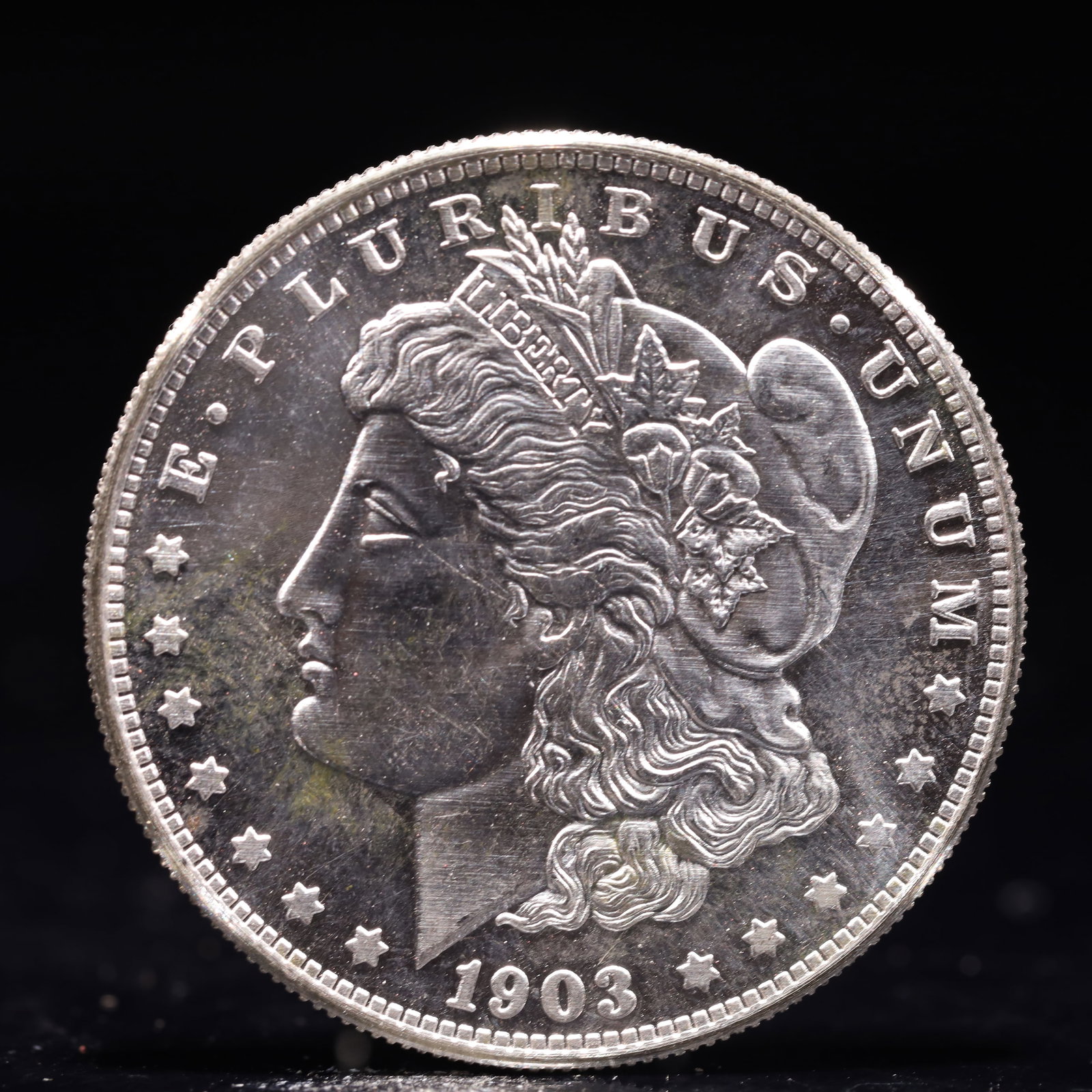 USA Morgan Dollar 1903 Coin: Obv: profile bust with date below and E PLURIBUS UNUM legend and stars around. Rev: eagle with In God we trust above within wreath with UNITED STATES OF AMERICA ONE DOLLAR legend. IN GOD WE TRUST / LI