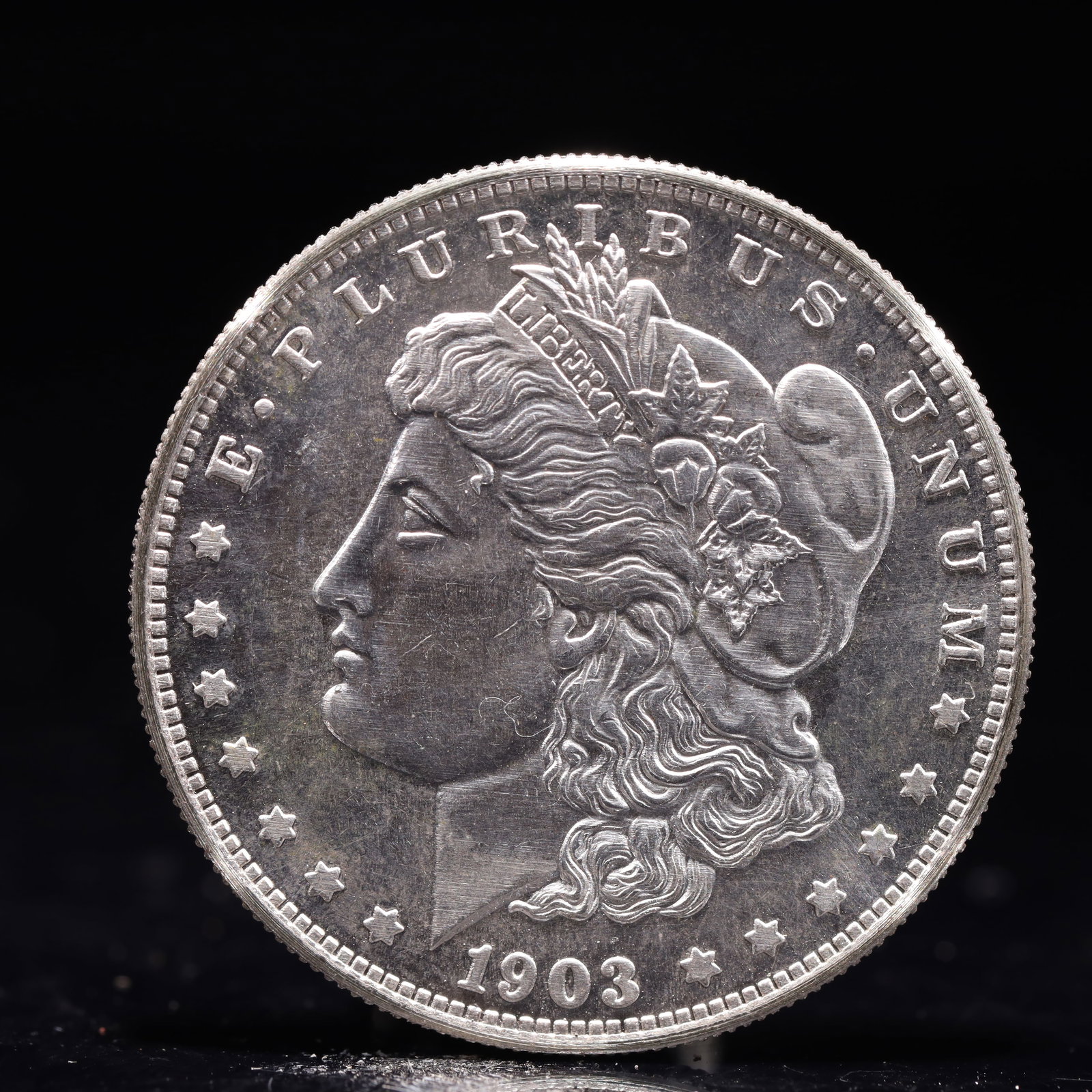 USA Morgan Dollar 1903 Coin: Obv: profile bust with date below and E PLURIBUS UNUM legend and stars around. Rev: eagle with In God we trust above within wreath with UNITED STATES OF AMERICA ONE DOLLAR legend. IN GOD WE TRUST /