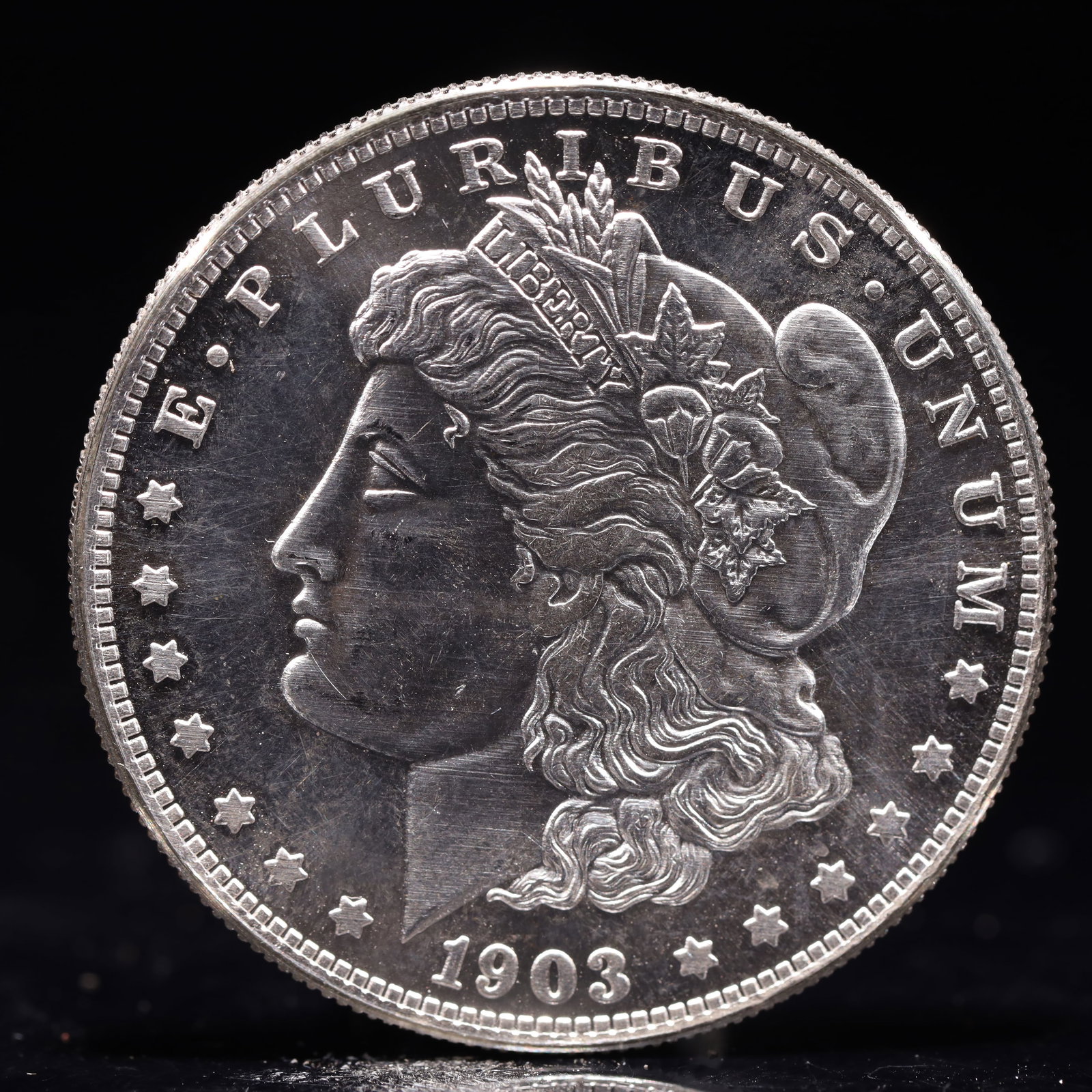 USA Morgan Dollar 1903 Coin: Obv: profile bust with date below and E PLURIBUS UNUM legend and stars around. Rev: eagle with In God we trust above within wreath with UNITED STATES OF AMERICA ONE DOLLAR legend. IN GOD WE TRUST /