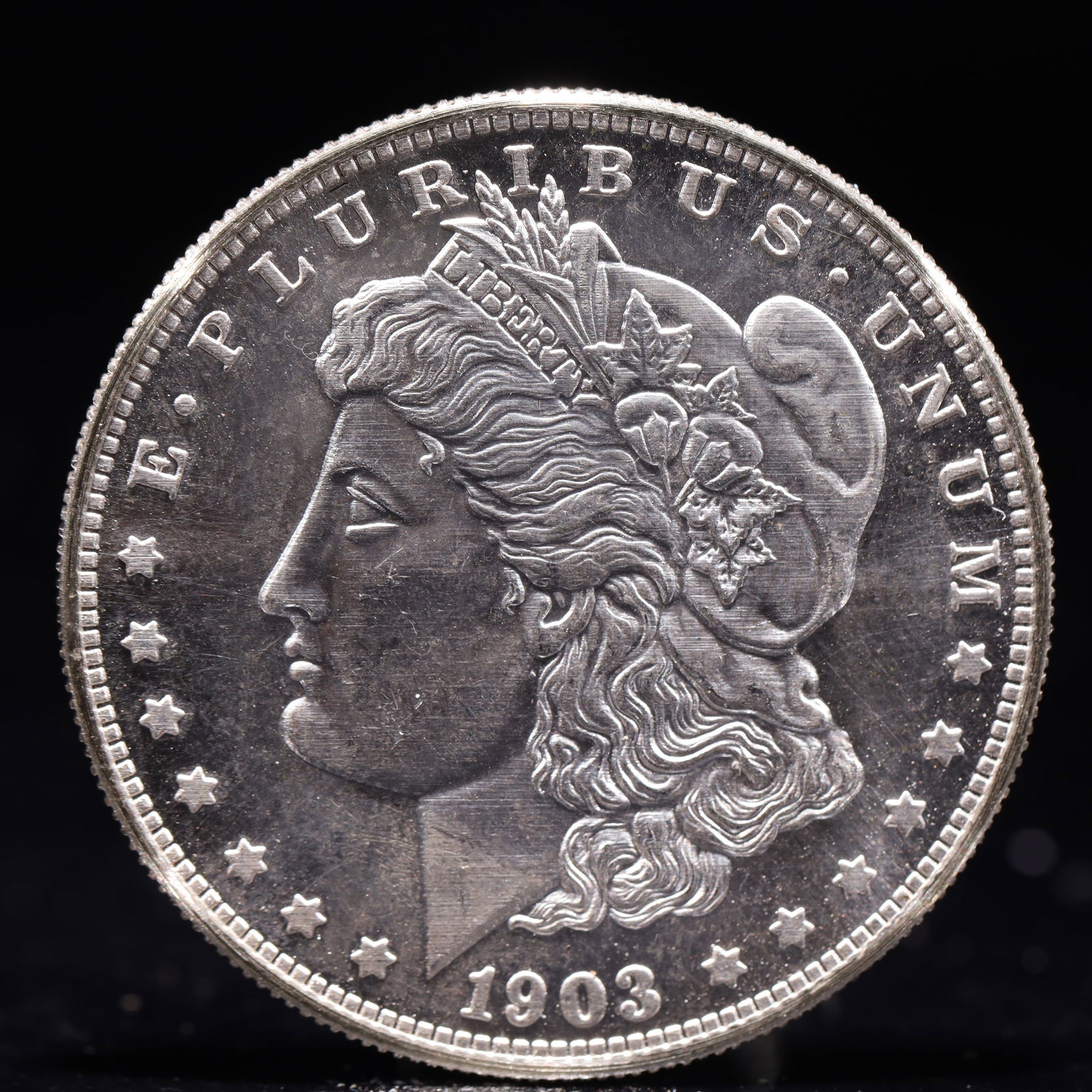 USA Morgan Dollar 1903 Coin: Obv: profile bust with date below and E PLURIBUS UNUM legend and stars around. Rev: eagle with In God we trust above within wreath with UNITED STATES OF AMERICA ONE DOLLAR legend. IN GOD WE TRUST / LI