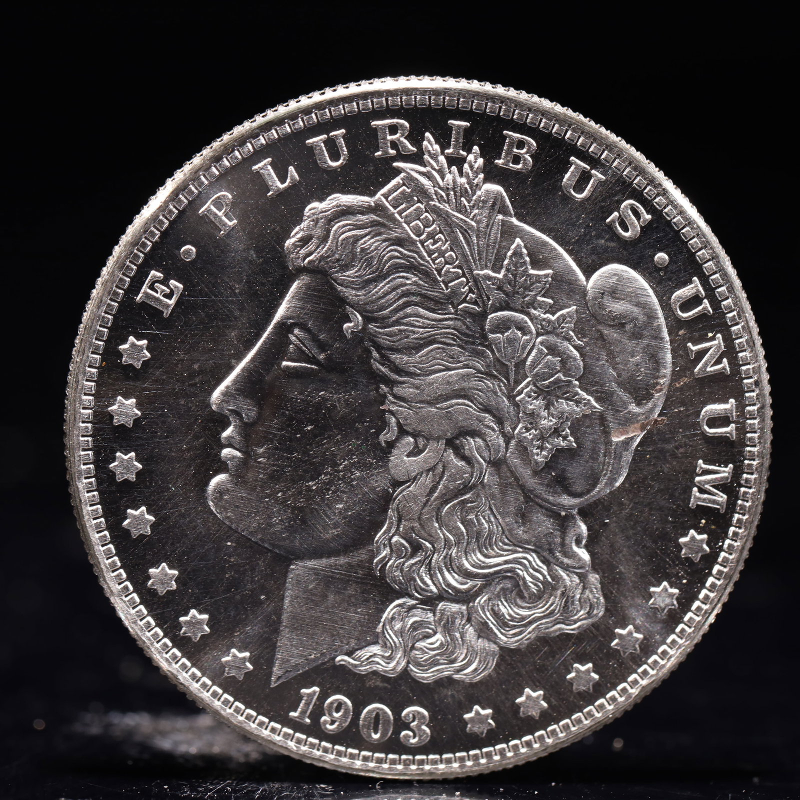 USA Morgan Dollar 1903 Coin: Obv: profile bust with date below and E PLURIBUS UNUM legend and stars around. Rev: eagle with In God we trust above within wreath with UNITED STATES OF AMERICA ONE DOLLAR legend. IN GOD WE TRUST / LI