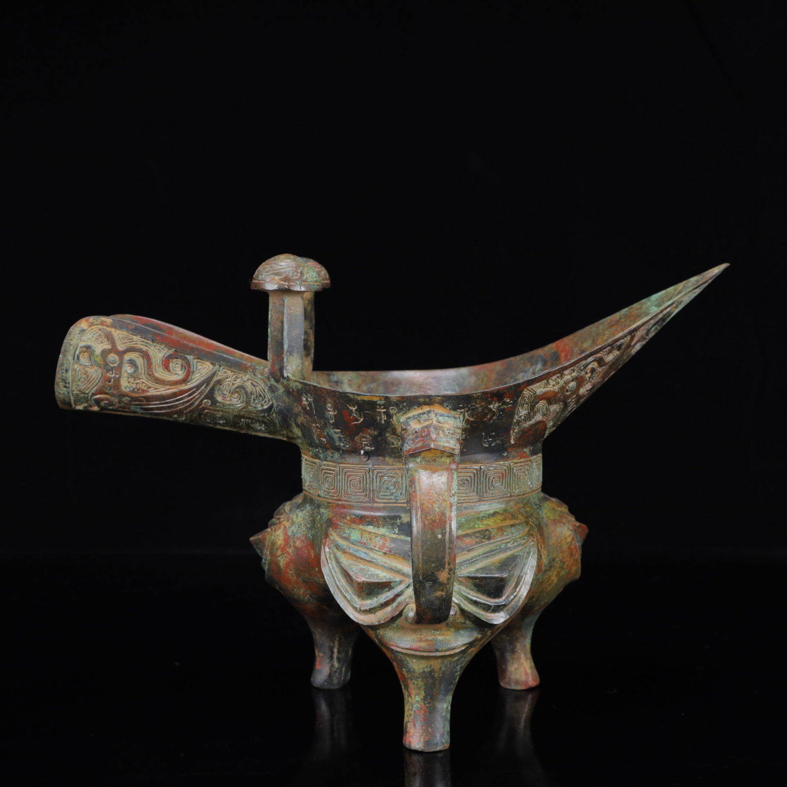 An Archaic Bronze Figure-Face Pattern Tripod Cup,with Inscription: An Archaic Bronze Figure-Face Pattern Tripod Cup,with Inscription,the Warring States Period in China,Size:12.2inx6.7inx8.3in,Weight:2050g 青铜人面纹三足੗