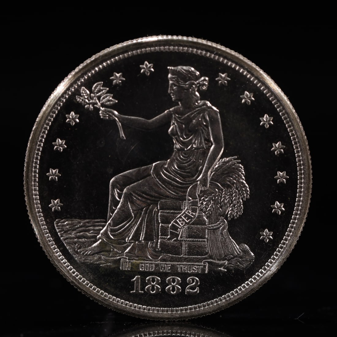 USA Trade Dollar 1882 Coin: American coin. Obverse: Liberty seated on a pedestal facing the sea to the left holding olive branches surrounded by 13 stars. IN GOD WE TRUST / LIBERTY / 1882. Reverse: An eagle holding branches with