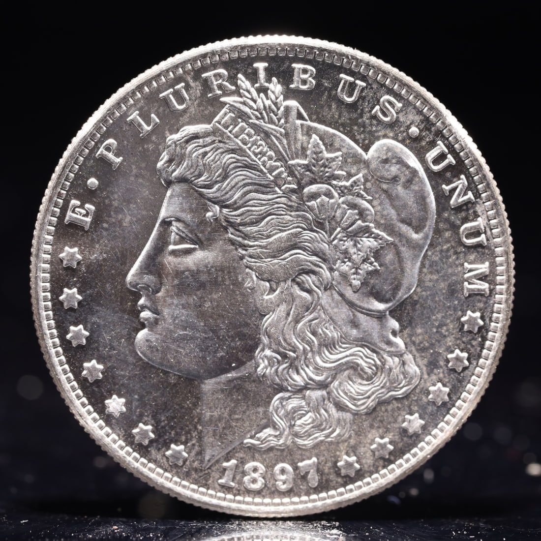 USA Morgan Dollar 1897 Coin: Obv: profile bust with date below and E PLURIBUS UNUM legend and stars around. Rev: eagle with In God we trust above within wreath with UNITED STATES OF AMERICA ONE DOLLAR legend. IN GOD WE TRUST / LI