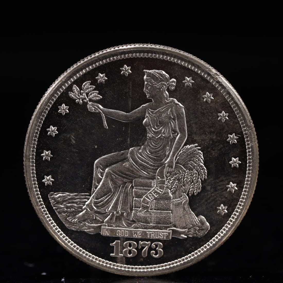 USA Trade Dollar 1873 Coin: American coin. Obverse: Liberty seated on a pedestal facing the sea to the left holding olive branches surrounded by 13 stars. IN GOD WE TRUST / LIBERTY / 1873. Reverse: An eagle holding branches