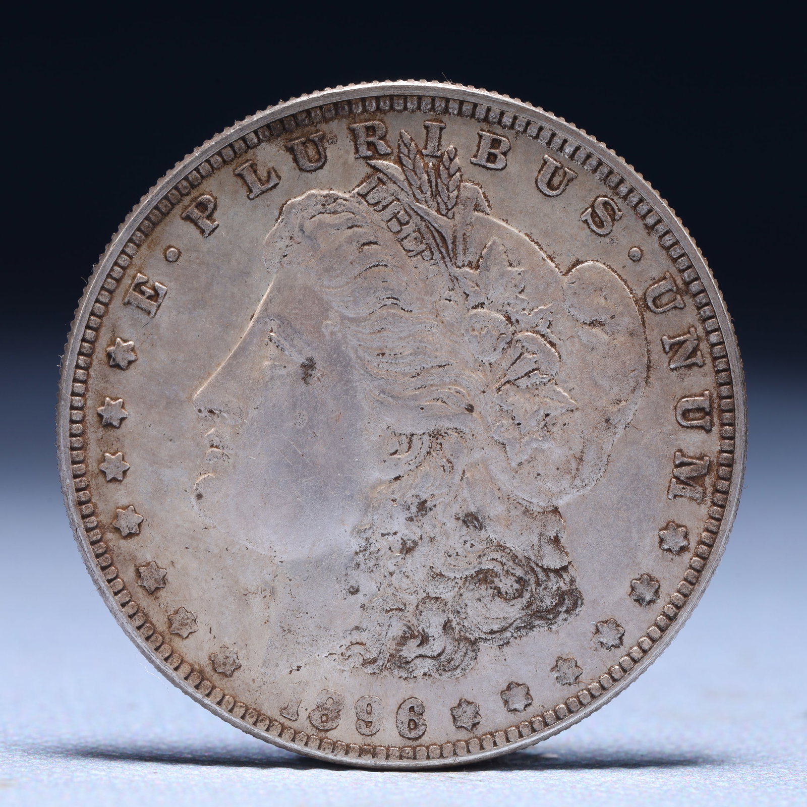 USA Morgan Dollar 1896 Coin: Obv: profile bust with date below and E PLURIBUS UNUM legend and stars around. Rev: eagle with In God we trust above within wreath with UNITED STATES OF AMERICA ONE DOLLAR legend. IN GOD WE TRUST / LI