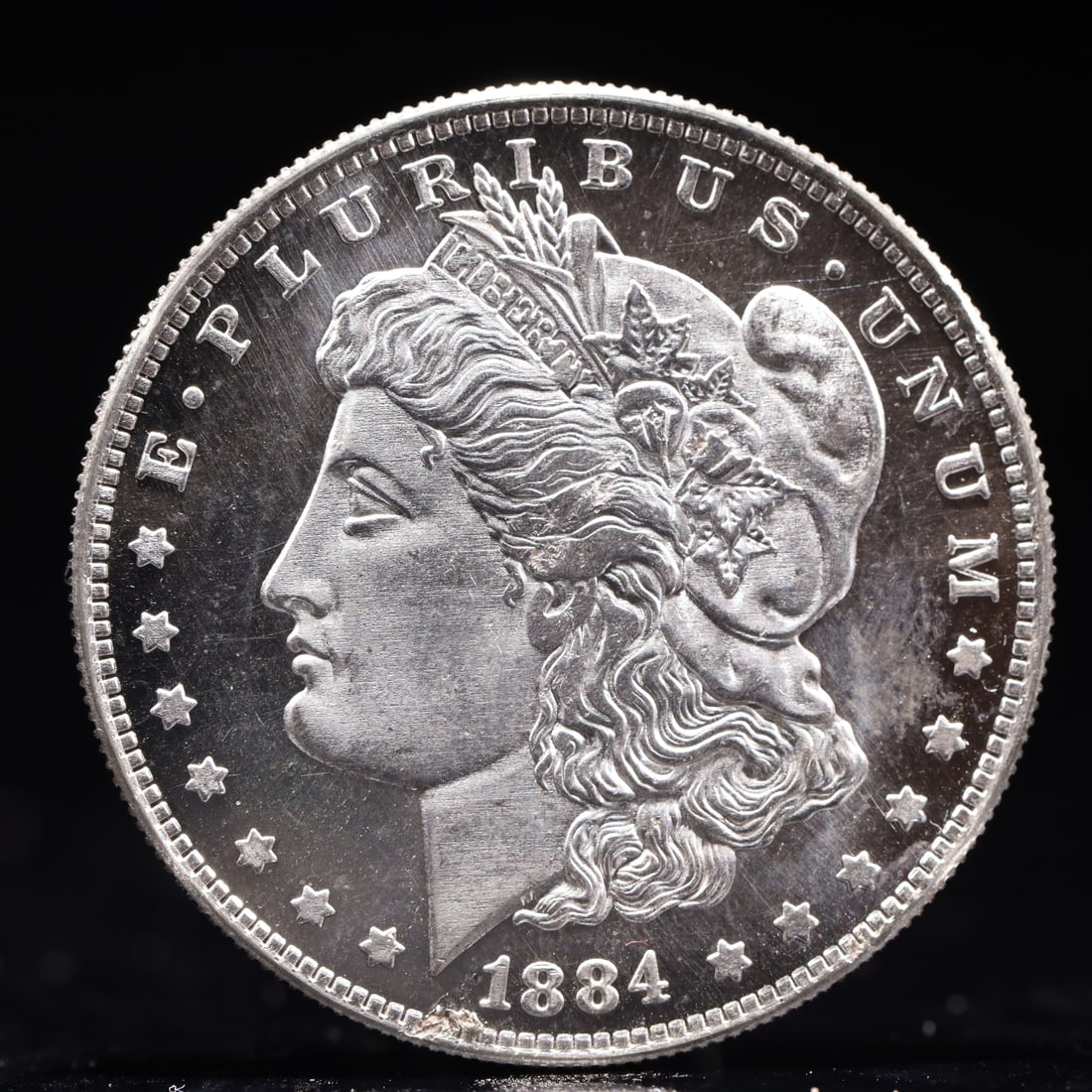 USA Morgan Dollar 1884 Coin: Obv: profile bust with date below and E PLURIBUS UNUM legend and stars around. Rev: eagle with In God we trust above within wreath with UNITED STATES OF AMERICA ONE DOLLAR legend. IN GOD WE TRUST /