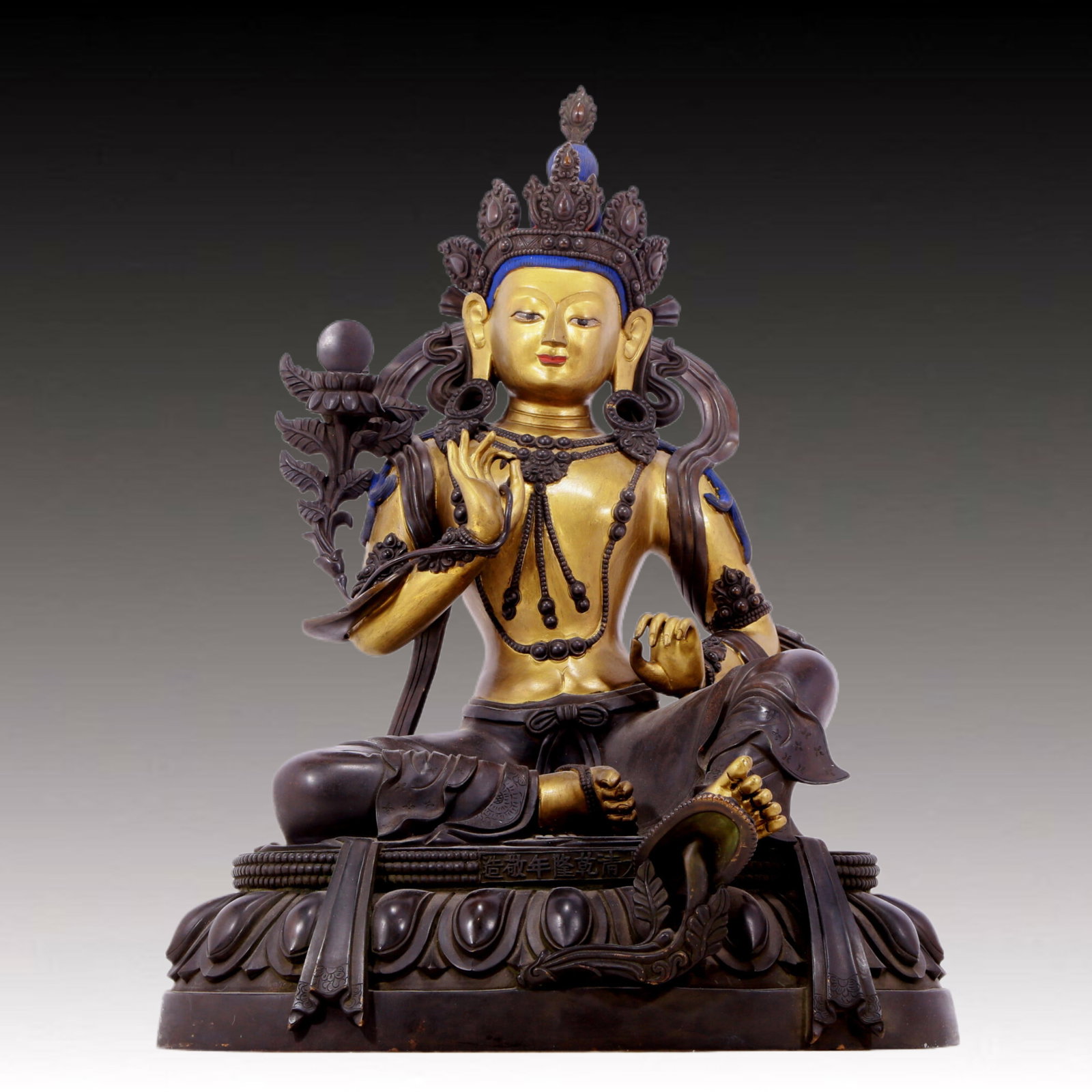 A solemn gilt bronze statue of green Tara: solemn gilt-bronze green Tara statue, Qianlong seven-character inscription, Qing Dynasty, China. Tara has an elegant posture with a peaceful and compassionate expression. Her face is soft and solemn, 
