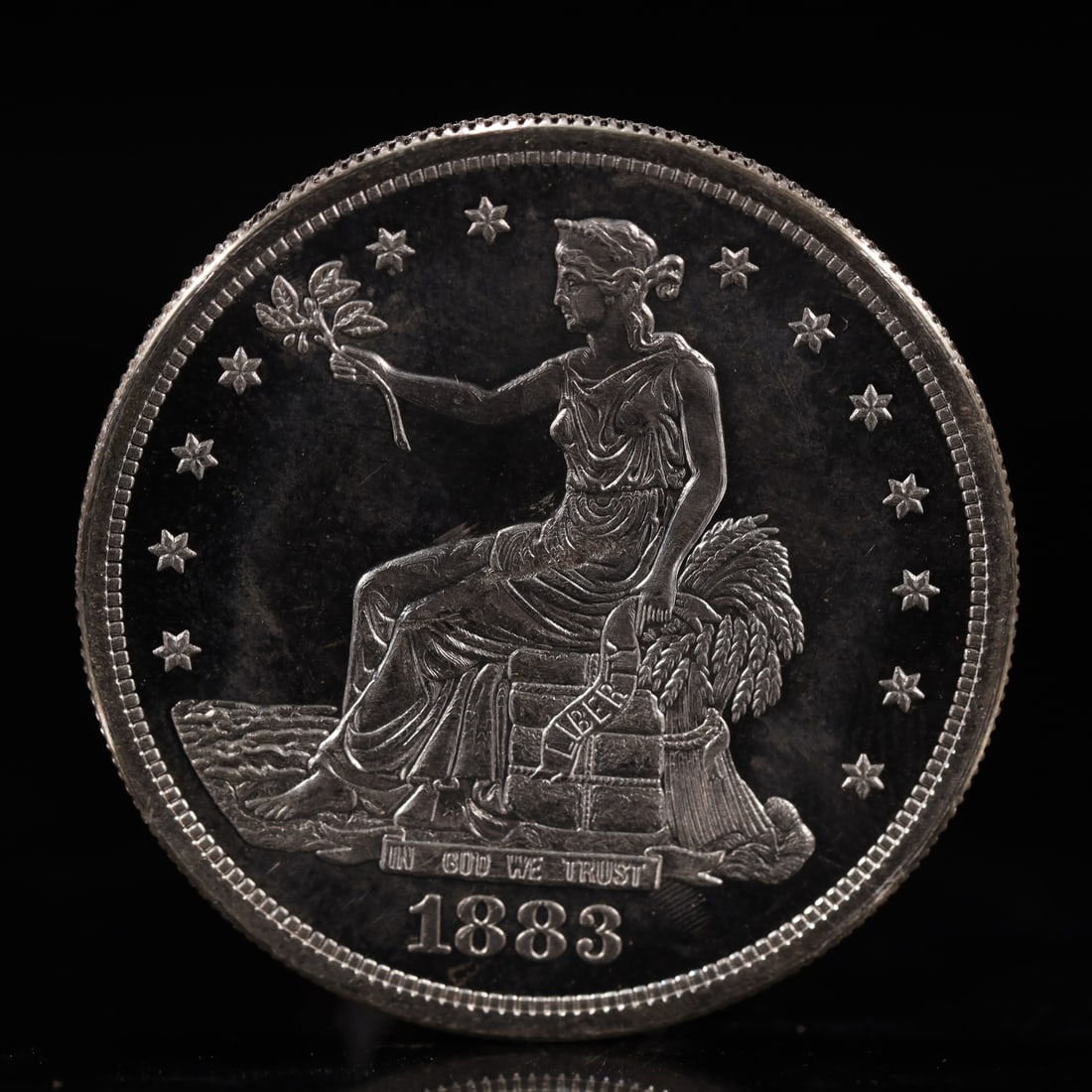 USA Trade Dollar 1883 Coin: American coin. Obverse: Liberty seated on a pedestal facing the sea to the left holding olive branches surrounded by 13 stars. IN GOD WE TRUST / LIBERTY / 1883. Reverse: An eagle holding branches