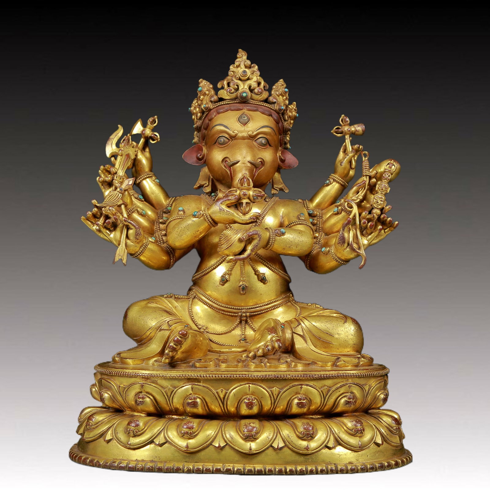 A solemn gilt bronze statue of the God of Wealth with an elephant trunk inlaid with precious stones: solemn gilt bronze statue of the Mammon with an elephant trunk inlaid with gems, from the Qing Dynasty of China. This is a breathtaking Buddhist work of art. The face of the Buddha statue is solemn an