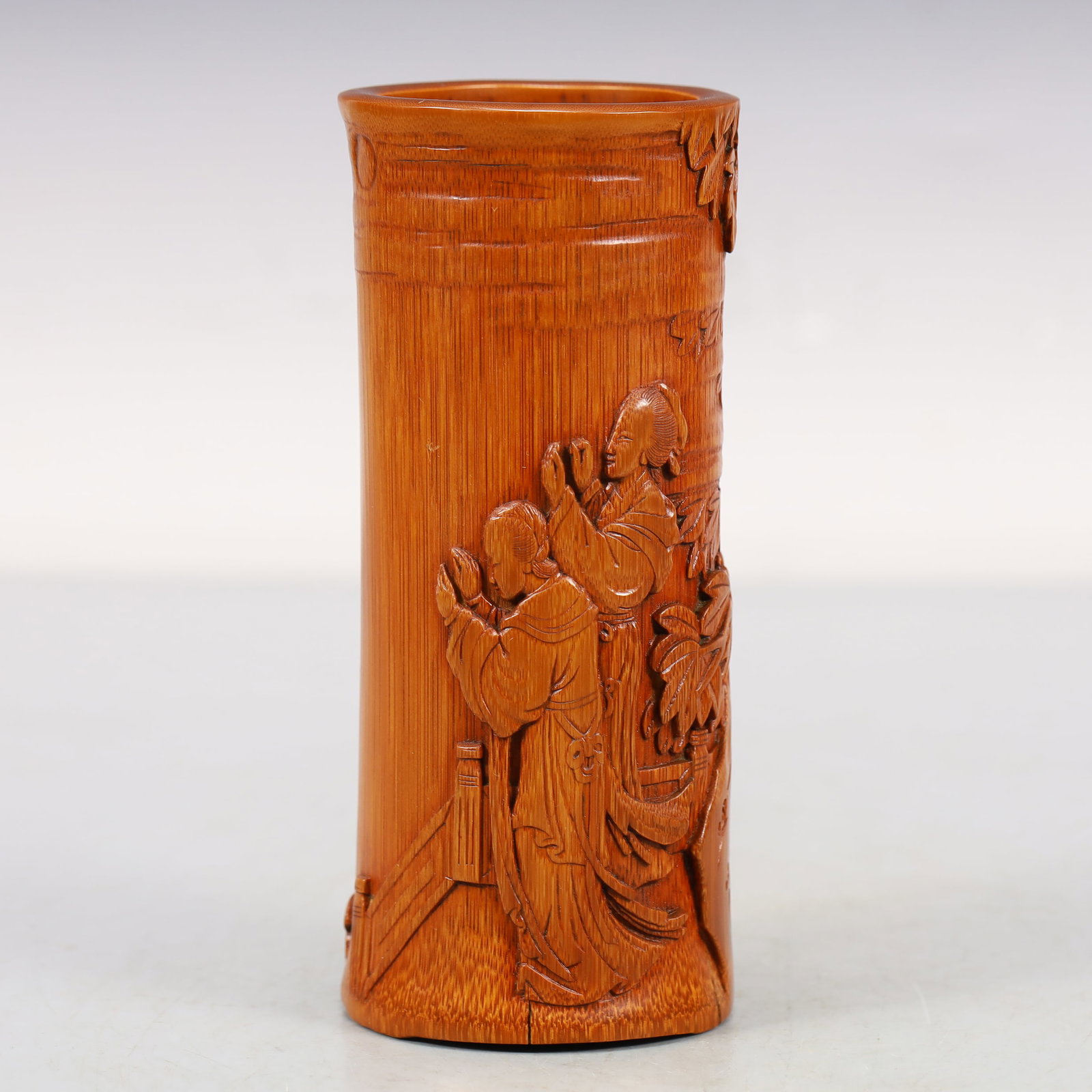A Bamboo 'Attendant Girl' Brush Pot: A Bamboo 'Attendant Girl' Brush Pot. Of a cylindrical shape,carved around the exterior with robed figures and lush plants. Chinese Qing Dynasty. Size:2.6inx6.2in 清代 竹雕É
