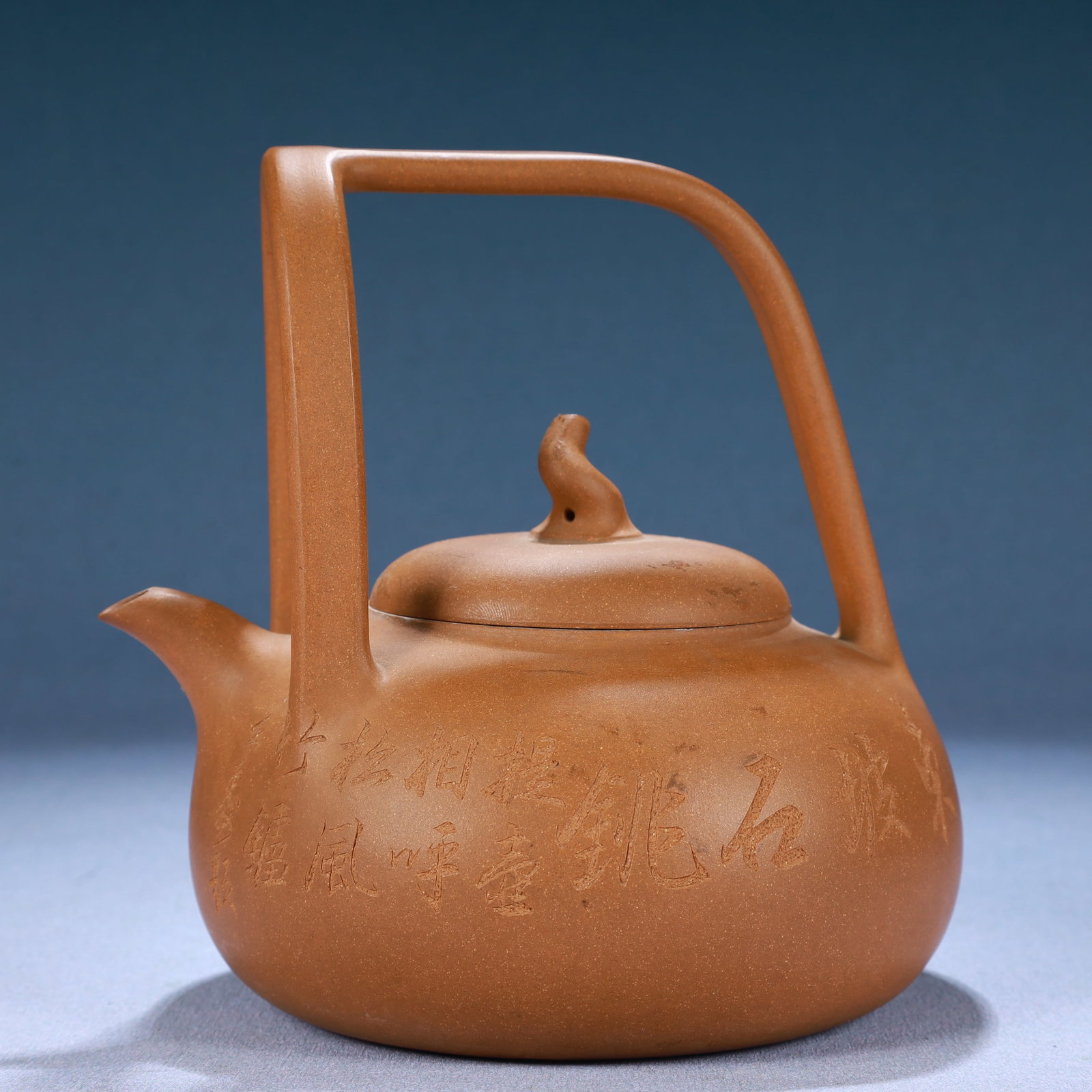 A Yixing Clay Ewer With Poem Inscriptions And An Overhead Handle: A Yixing Clay Ewer With Poem Inscriptions And An Overhead Handle. Made by Yu Chengyao. Size:5.9inx5.1inx5.9in 紫砂提梁壶,带诗文,玉成窑