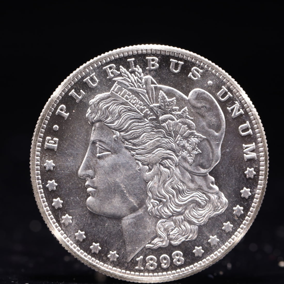 USA Morgan Dollar 1898 Coin: Obv: profile bust with date below and E PLURIBUS UNUM legend and stars around. Rev: eagle with In God we trust above within wreath with UNITED STATES OF AMERICA ONE DOLLAR legend. IN GOD WE TRUST / LI