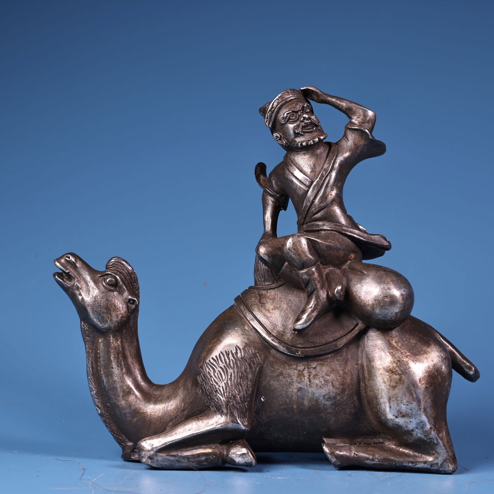 An Exquisite Silver Bronze Figure Riding Camel Ornament: An Exquisite Silver Bronze Figure Riding Camel Ornament,Qing Dynasty,China,Size:5.9inx6.3in,Weight:1100g 铜鎏银人物骑骆驼摆件,中ࢲ